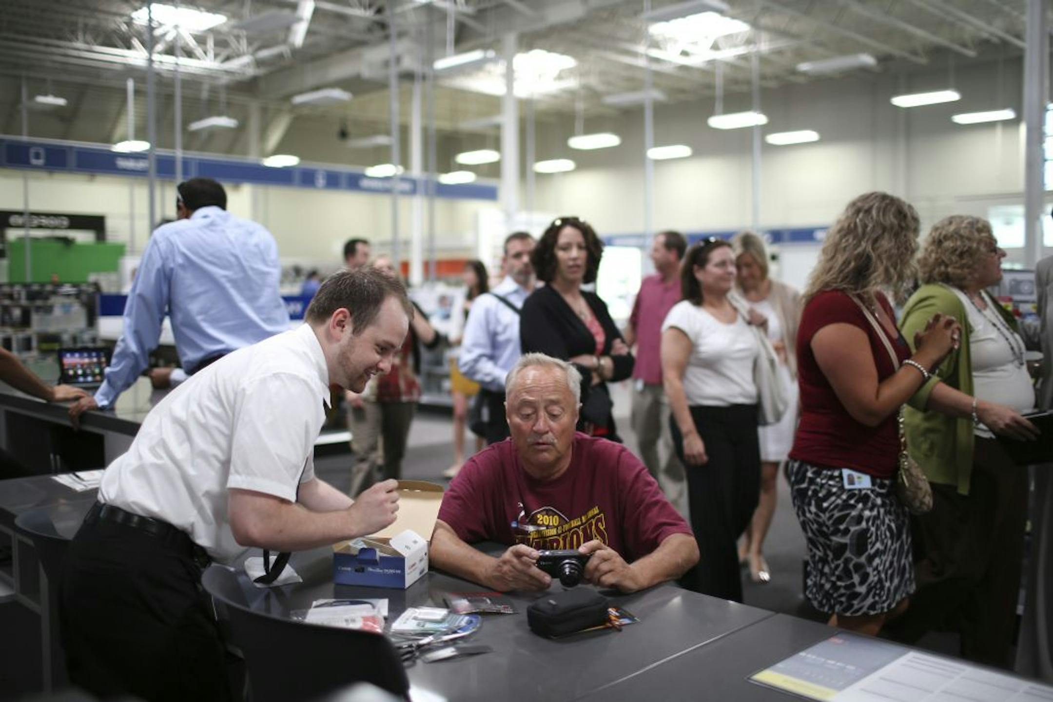 Best Buy is debuting its new Connected Store concept at their flagship store in Richfield. The store features a "Geek Squad Solution Center" in the middle of the skylighted sales floor in order to place greater emphasis on personalized customer service. Brad Gerlach of Gilbert, Minn., got some advice on his newly purchased digital camera from Mark Sonntag, aka Agent Sonntag of the Geek Squad at Solution Central in the middle of the newly remodeled Best Buy store in Richfield, Minn., Thursday aft