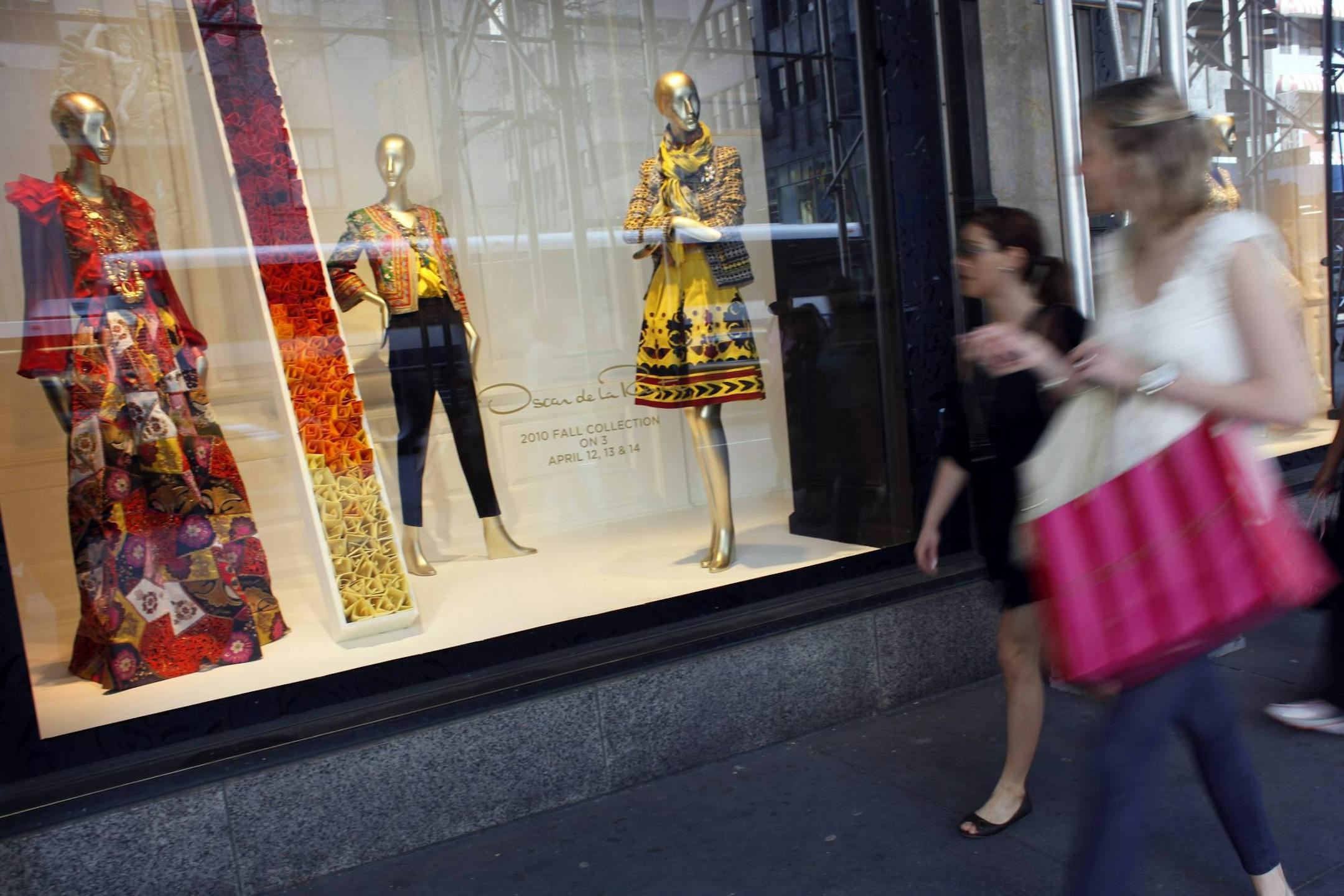 Shoppers walk past the the Oscar de la Renta display at the Saks 5th Ave. retail store, Thursday, April 8, 2010 in New York. Luxury retailer Saks Inc.'s sales at stores open at least a year grew 12.7 percent in March, lifted by strong results in women's designer clothing, handbags, men's clothing and accessories. (AP Photo/Mary Altaffer)