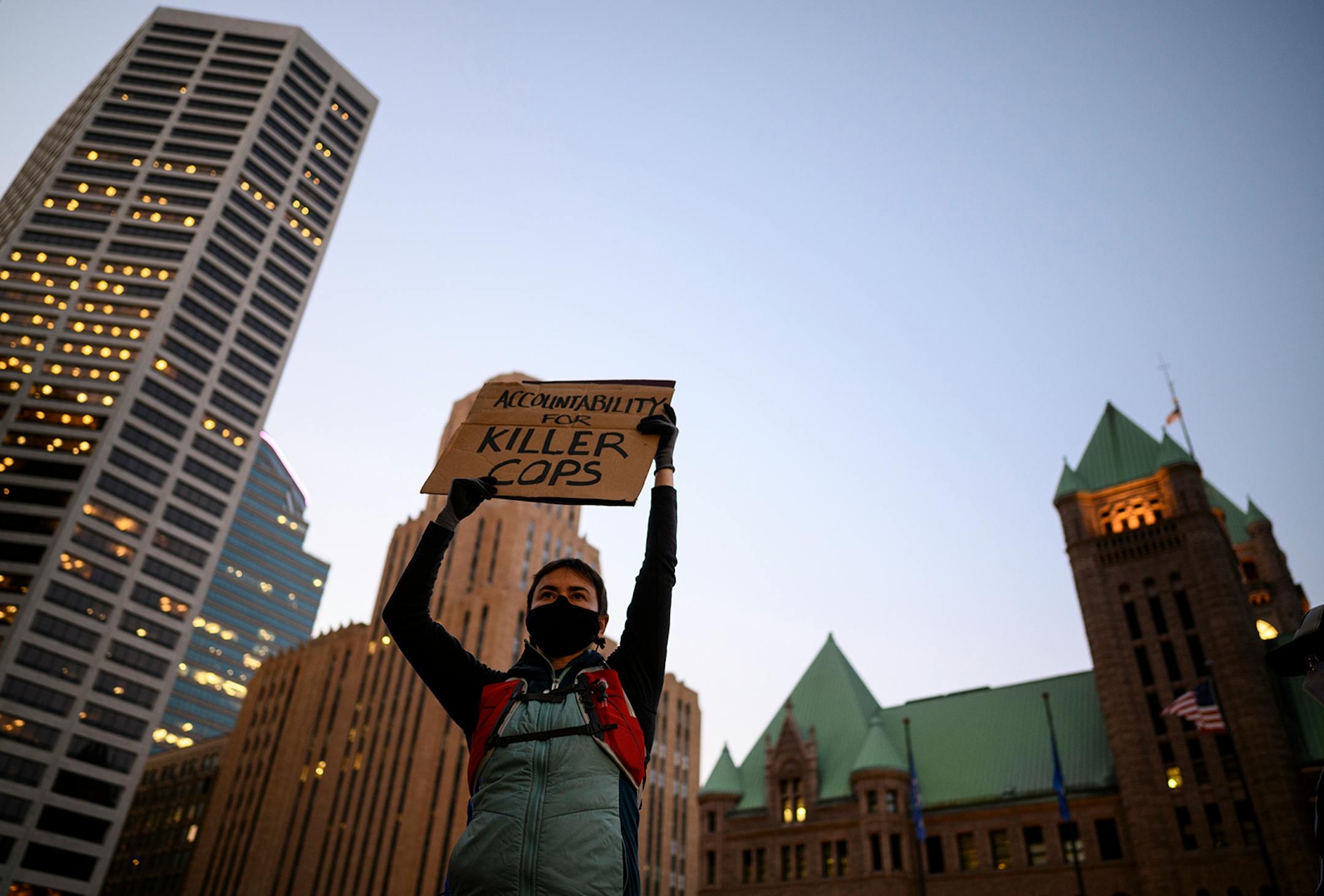 A proteter listened to speakers outside Hennepin County Government Center while holding up a sign, a day after the release of Derek Chauvin, the former Minneapolis Police officer charged with murdering George Floyd.