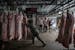 Workers unload pig carcasses at a warehouse that is part of China's national pork reserve, in Beijing, Sept. 27, 2019. The tariff fight has added to C