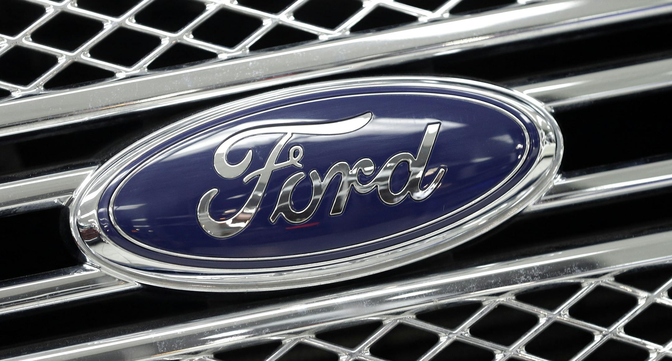 FILE - In this Jan. 5, 2015, file photo, the Ford logo shines on the front grille of a 2014 Ford F-150, on display at a local dealership in Hialeah, Fla. Ford will build a new $1.6 billion factory in Mexico, creating about 2,800 jobs and shifting small-car production from the U.S. The announcement Tuesday, April 5, 2016 comes at a time when moving jobs to the south has become a major issue in the U.S. presidential campaign. (AP Photo/Alan Diaz, File)