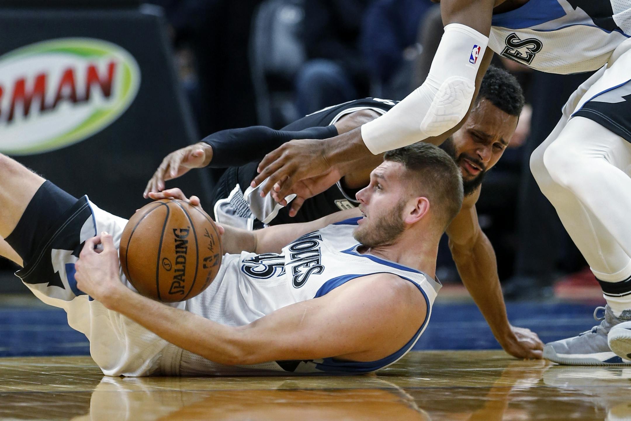 San Antonio Spurs guard Patty Mills (8) tries to get a loose ball from Minnesota Timberwolves center Cole Aldrich (45) and succeeds in getting a jump ball in the second half of an NBA basketball game, Tuesday, Dec. 6, 2016, in Minneapolis. The Spurs won 105-91.