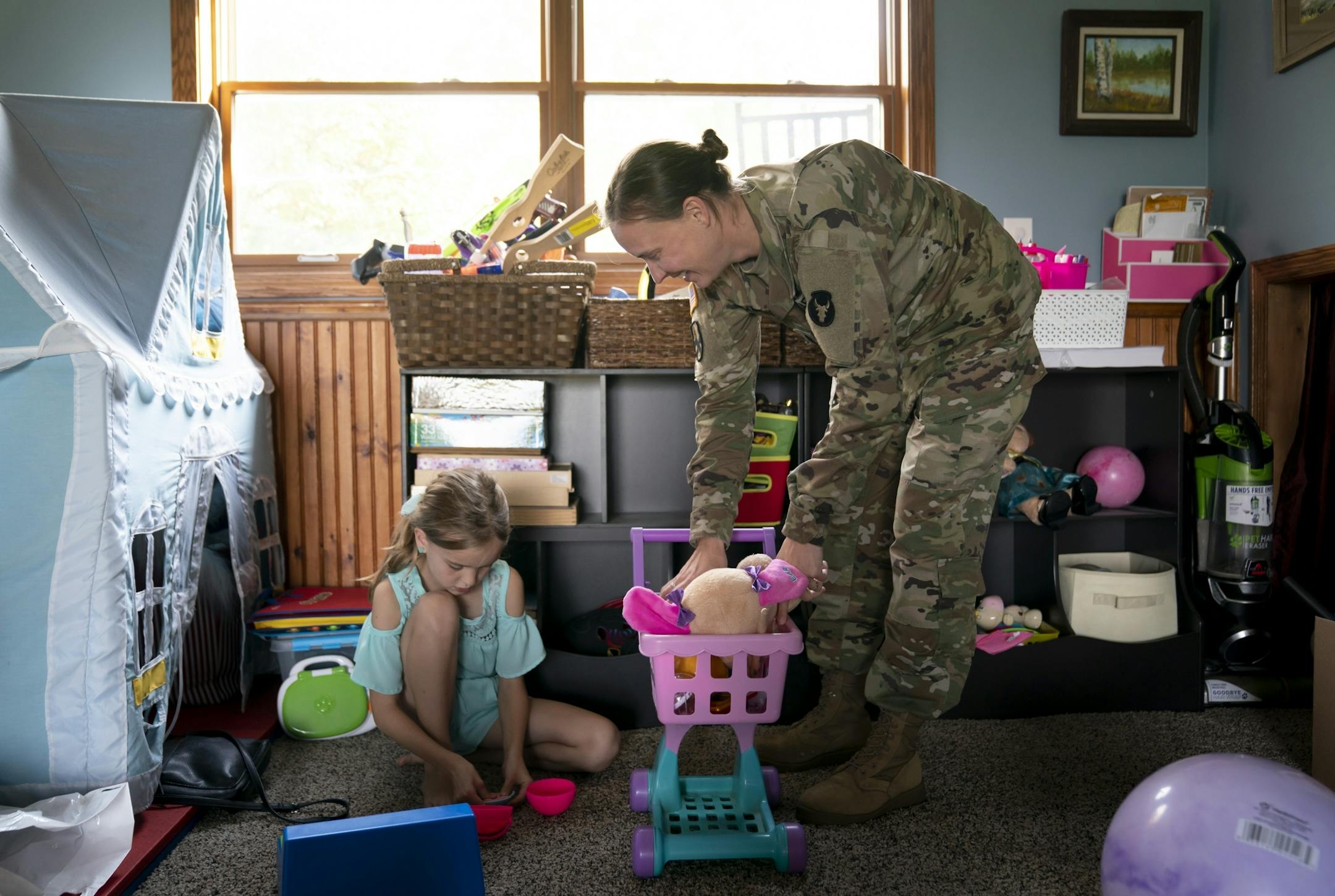 Jeanette Chafee played grocery store with her daughters Madison, 8, and Ally, 3, at home in Scandia, Minn., on Wednesday, September 18, 2019. Chafee was in her uniform after coming home from work.