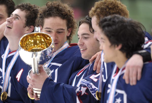 The Wild drafted a champion in Louis Belpedio, center, who posed with the winning trophy after the United States won the gold medal game of the U18 Wo