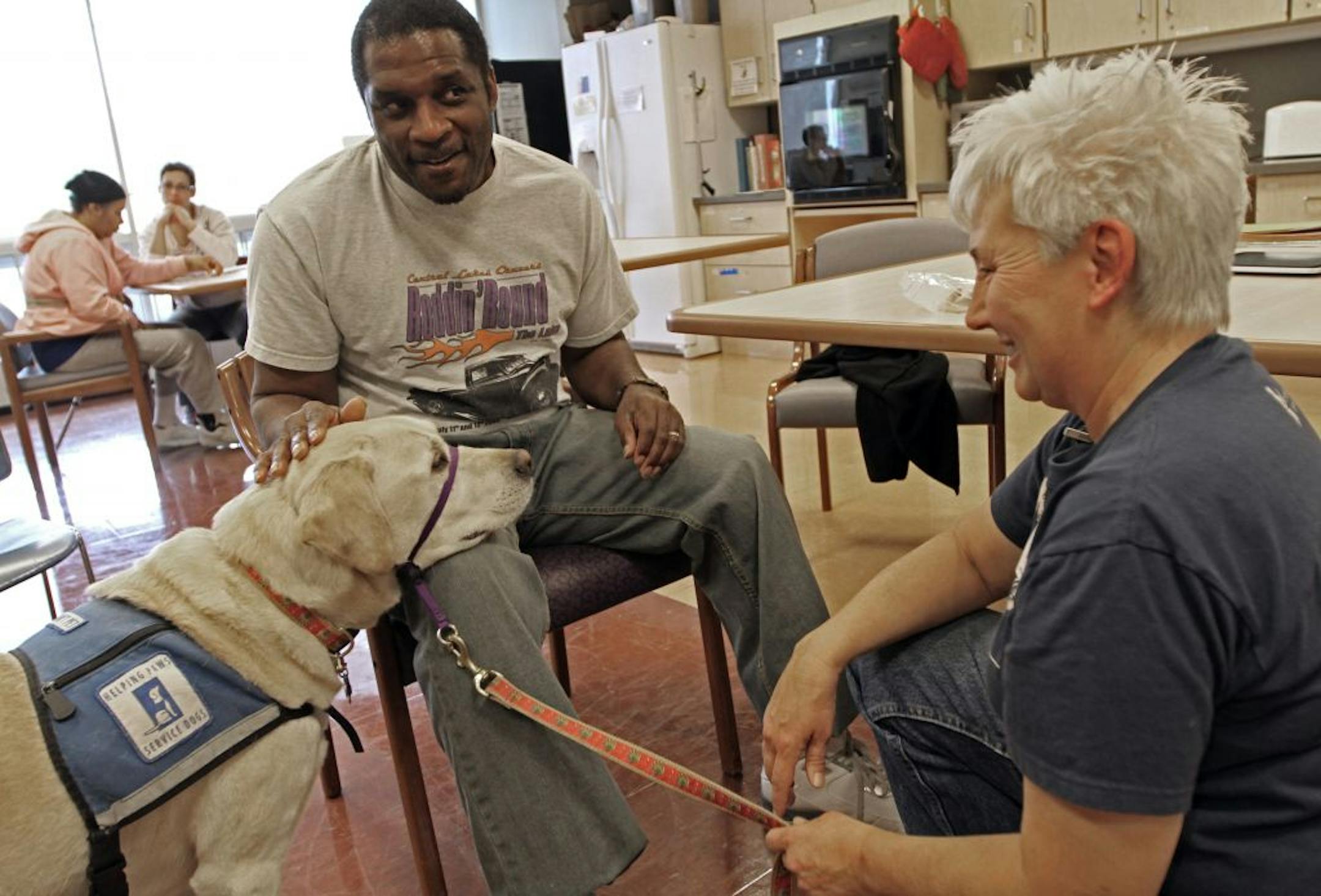 (left to right) Hudy the dog met with Courage Center patient Kevin Walton as handler Liz Louis looked on, at the Courage Center in Golden Valley on 11/8/12. Hudy is a multi-tasking canine as he helps with rehab at the Courage Center and has the role of Sandy in the Lyric Arts theater's production of "Annie."