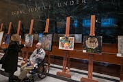 Bill Crane, 60, talks with his guardian Christy Marchand in front of his untitled artwork as part of an "I AM” show on display in the lobby of the U