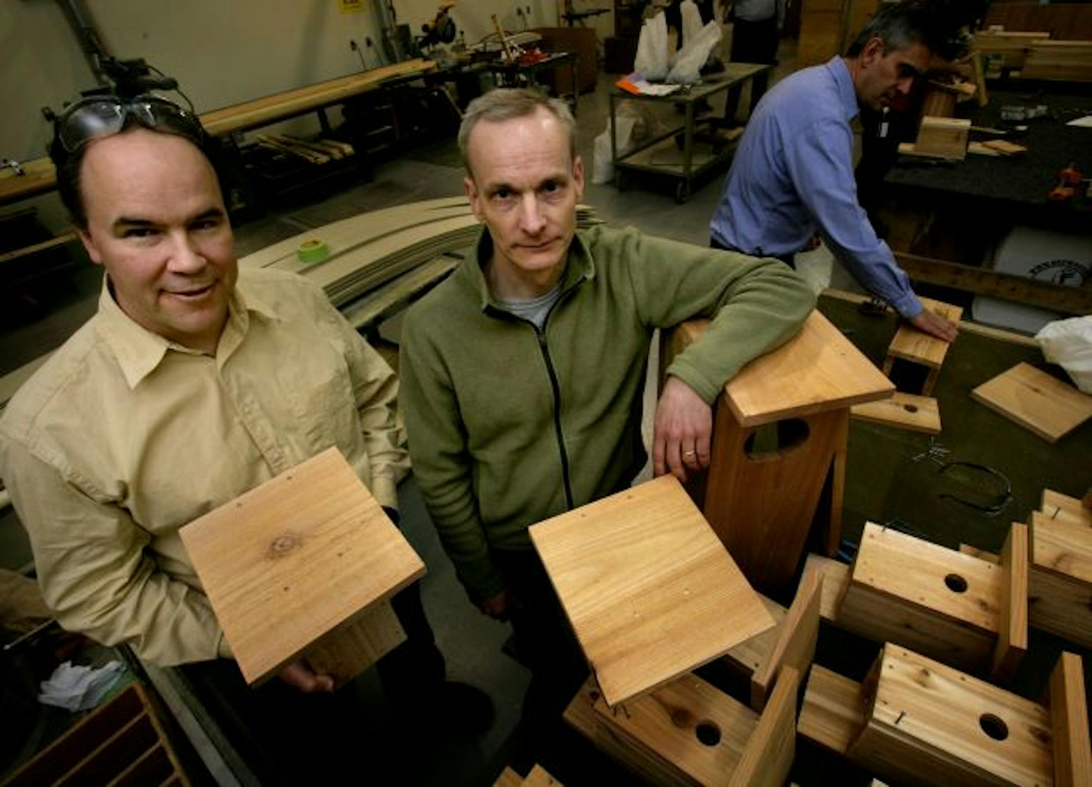 (L to R) Timothy Nixon and Richard Baum head a group of volunteers that assembled bird houses which were assembled in the wood shop in the Thomson Reuters headquarters. Bruce Bevis (background was one of the volunteers that put the bird houses together.