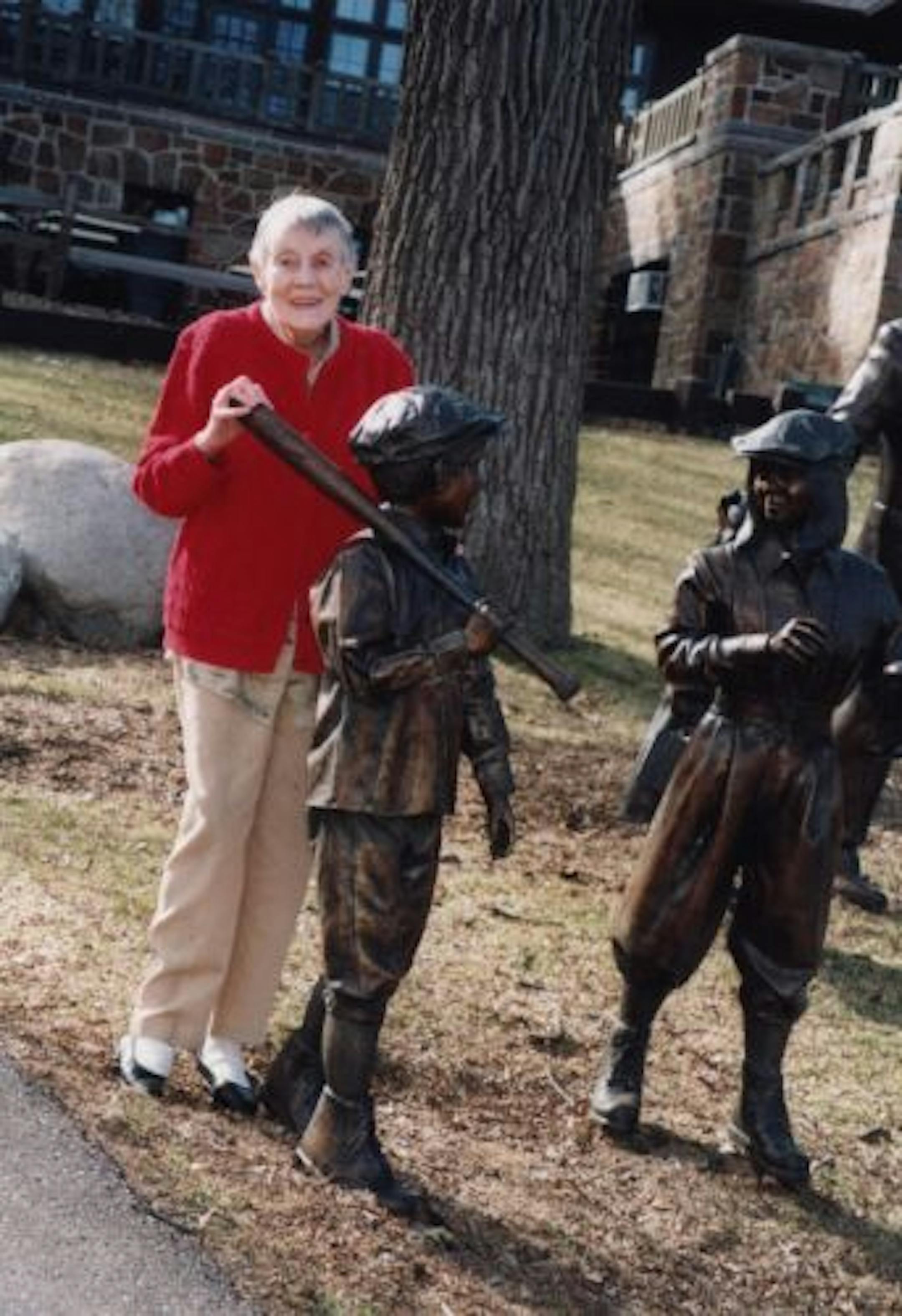 Elizabeth Boyer with softball children statues.