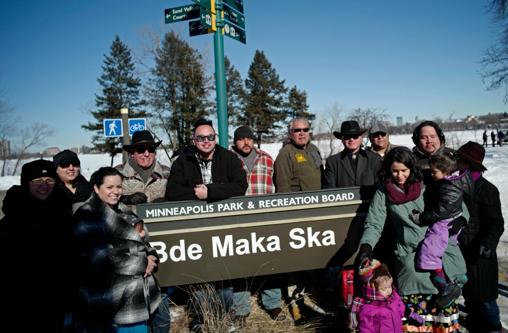 People gathered around the Bde Maka Ska sign in Minneapolis.