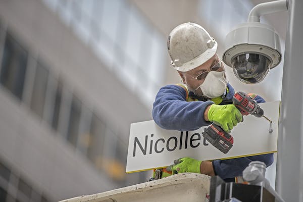 Jason Gehrke, cq, of Albrecht Signs, installed new signs at 8th and Nicollet along the Nicollet Mall, Friday, October 13, 2017 in Minneapolis, MN. ] E