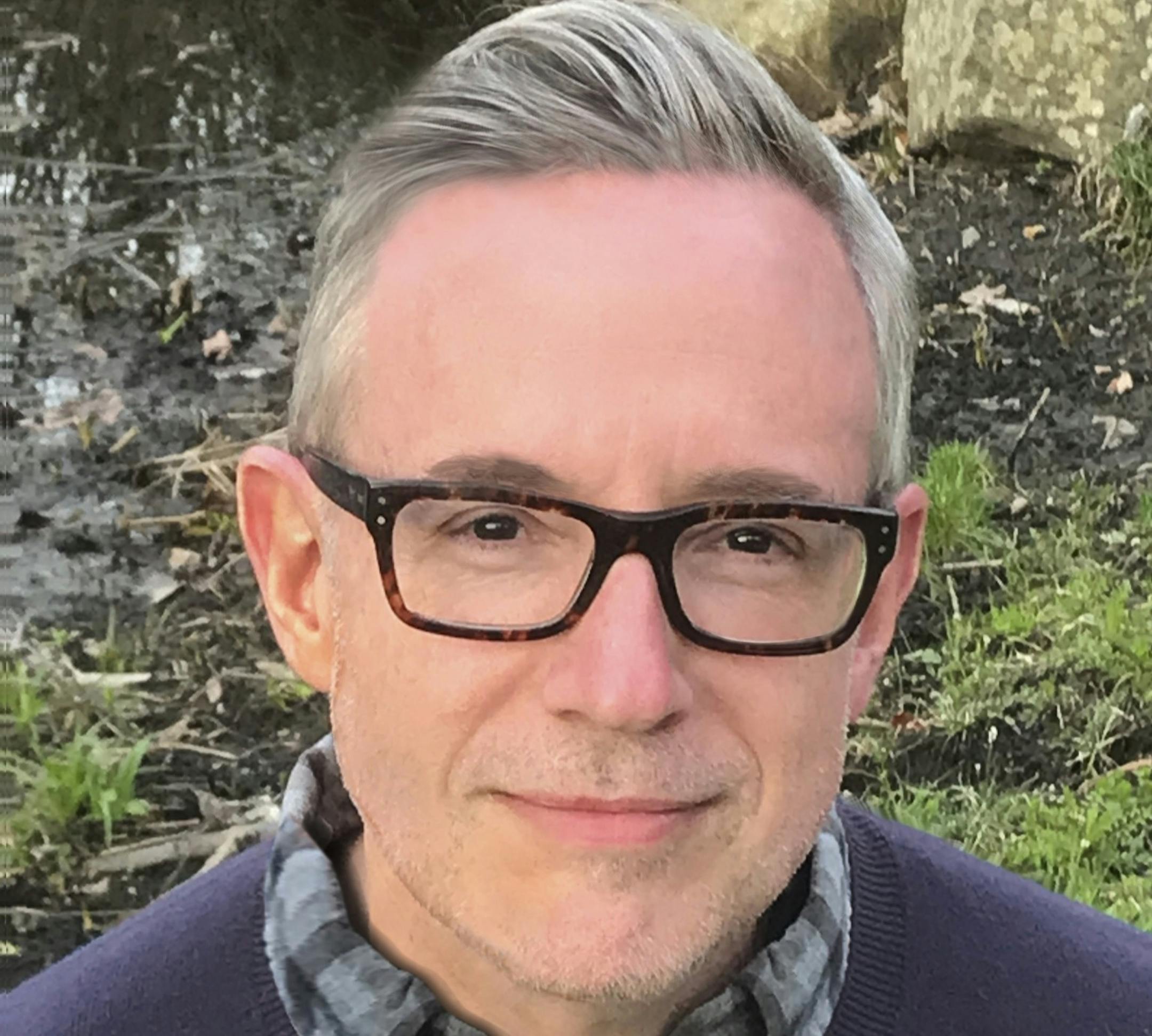 outdoors photo of author Patrick Ryan in a plaid shirt and sweater