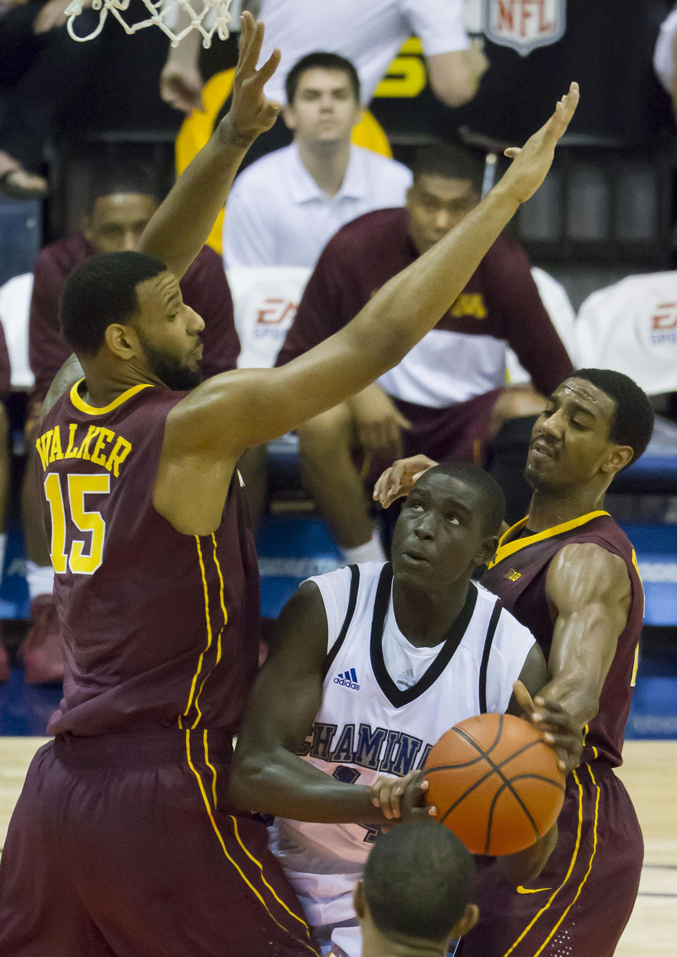 Chaminade forward Kuany Kuany, center, looks for an opening to take a shot while being defended by Minnesota forward Maurice Walker (15) and guard Austin Hollins, right, in the first half of an NCAA college basketball game at the Maui Invitational on Wednesday, Nov. 27, 2013, in Lahaina, Hawaii. (AP Photo/Eugene Tanner)