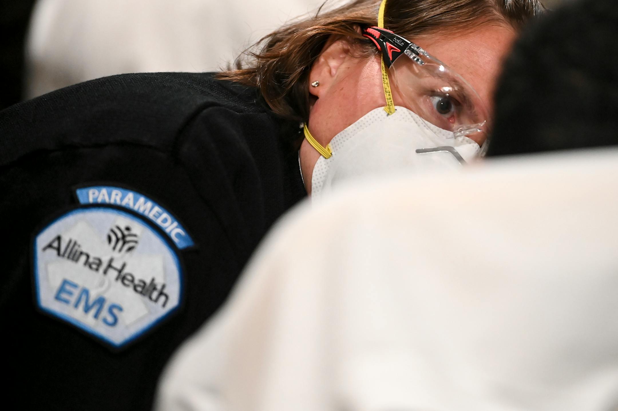 Allina Health Paramedic Crystal Gaughan leaned down to speak to a 12-year old patient, suspected of having COVID-19, before transporting them to a local hospital Wednesday. ] AARON LAVINSKY • aaron.lavinsky@startribune.com Emergency medical workers and physician Andrew Stevens responded to possible COVID-19 related calls on Wednesday, Dec. 2, 2020 in the north Twin Cities metro.