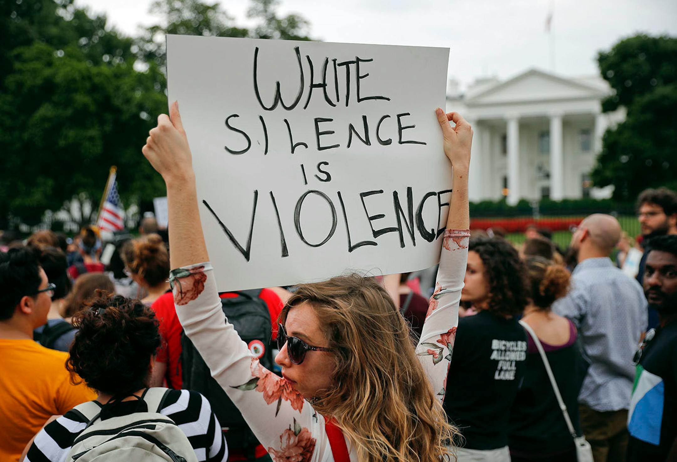 Demonstrators gather on Pennsylvania Avenue in front of the White House in Washington, Monday, Aug. 14, 2017. For the second night in a row, people gathered in front of the White House to protest the white nationalist rally in Charlottesville, Va.
