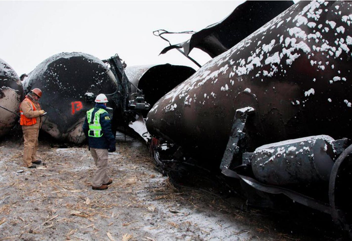 National Transportation Safety Board member Robert Sumwalt, right, views damaged rail cars in Casselton, N.D.