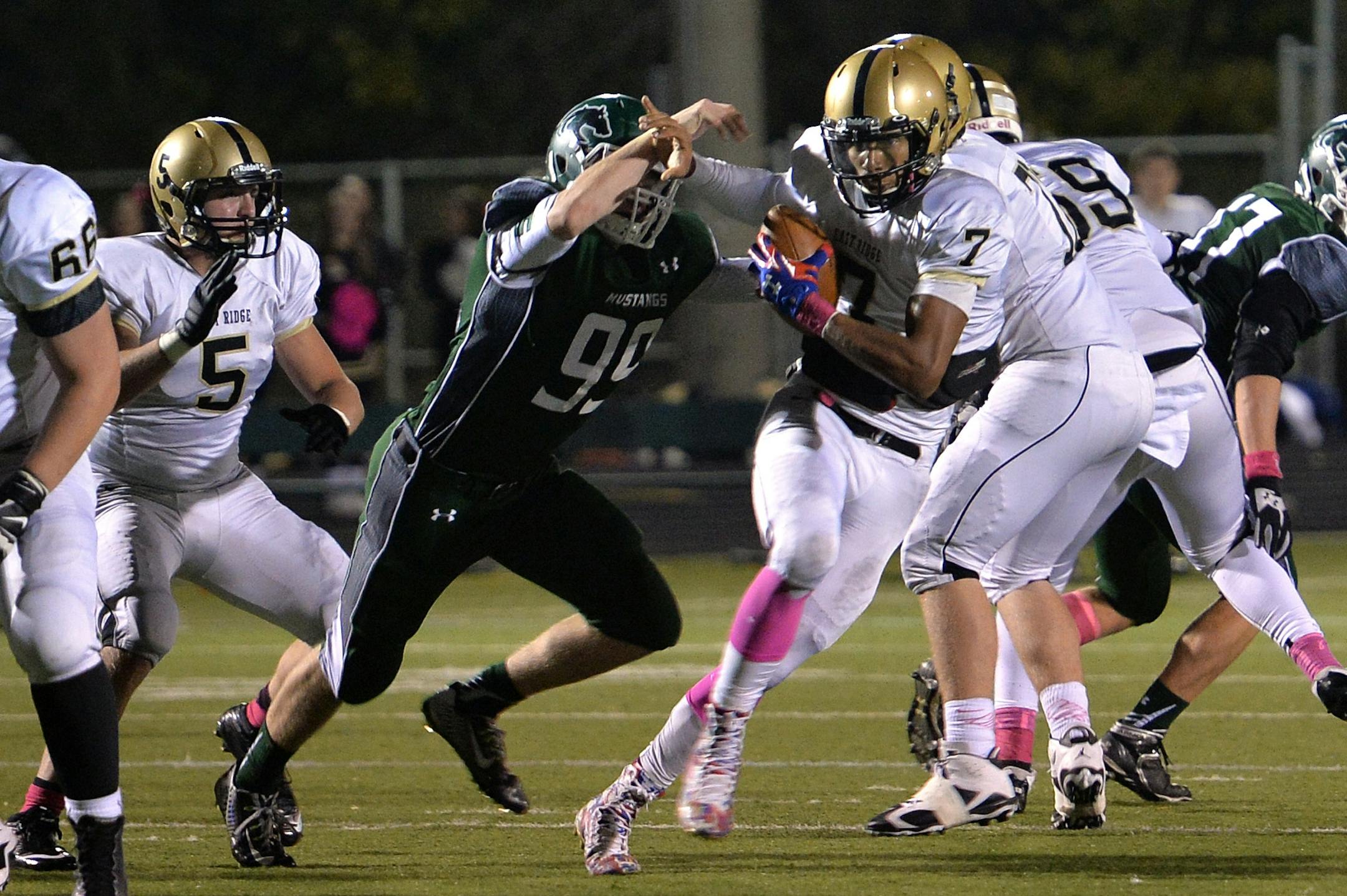 East Ridge quarterback Seth Green (7) pushed through Mounds View's defense in 2014.