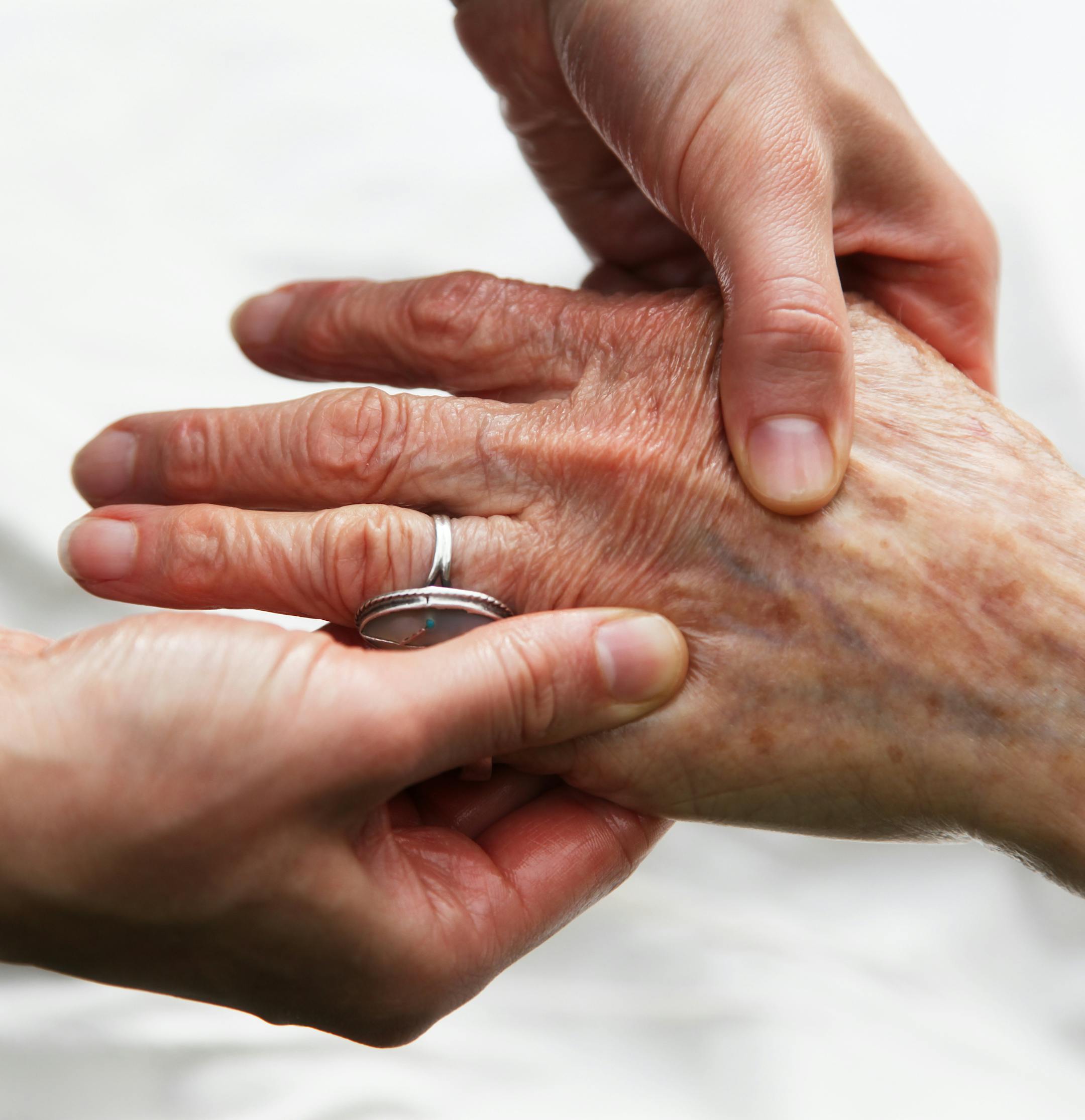 Elderly woman receiving a gentle healing massage on her hands. istock