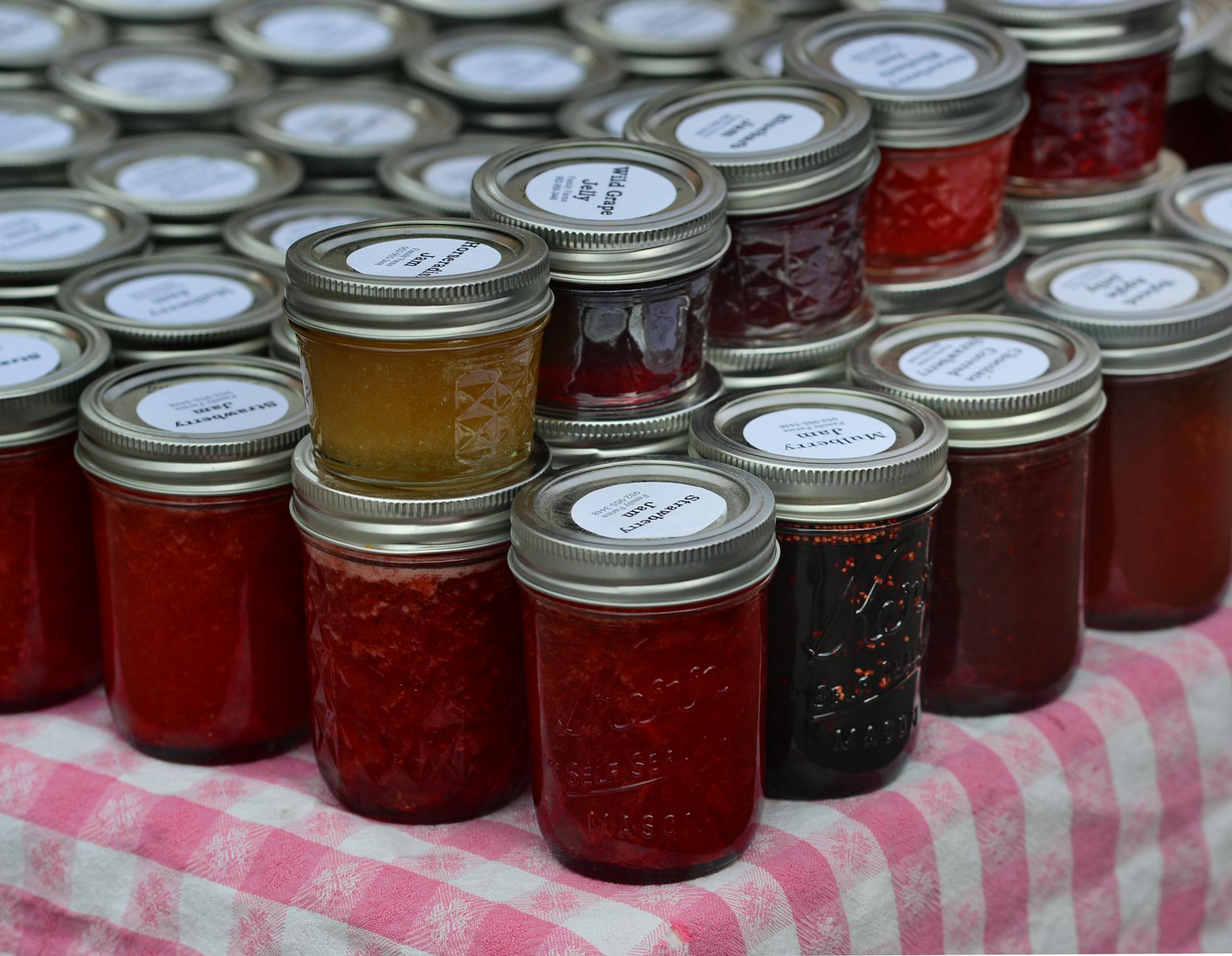 Deb Hoen, of Family Farms in Delano put out jars of fruit preserves, she produces maple syrup and fruit preserves and jams on her farm growing all of the ingredients .] Farmers Market in Excelsior on Water Street Richard.Sennott@startribune.com Richard Sennott/Star Tribune Excelsior Minn. Thursday 5/08/2014) ** (cq)
