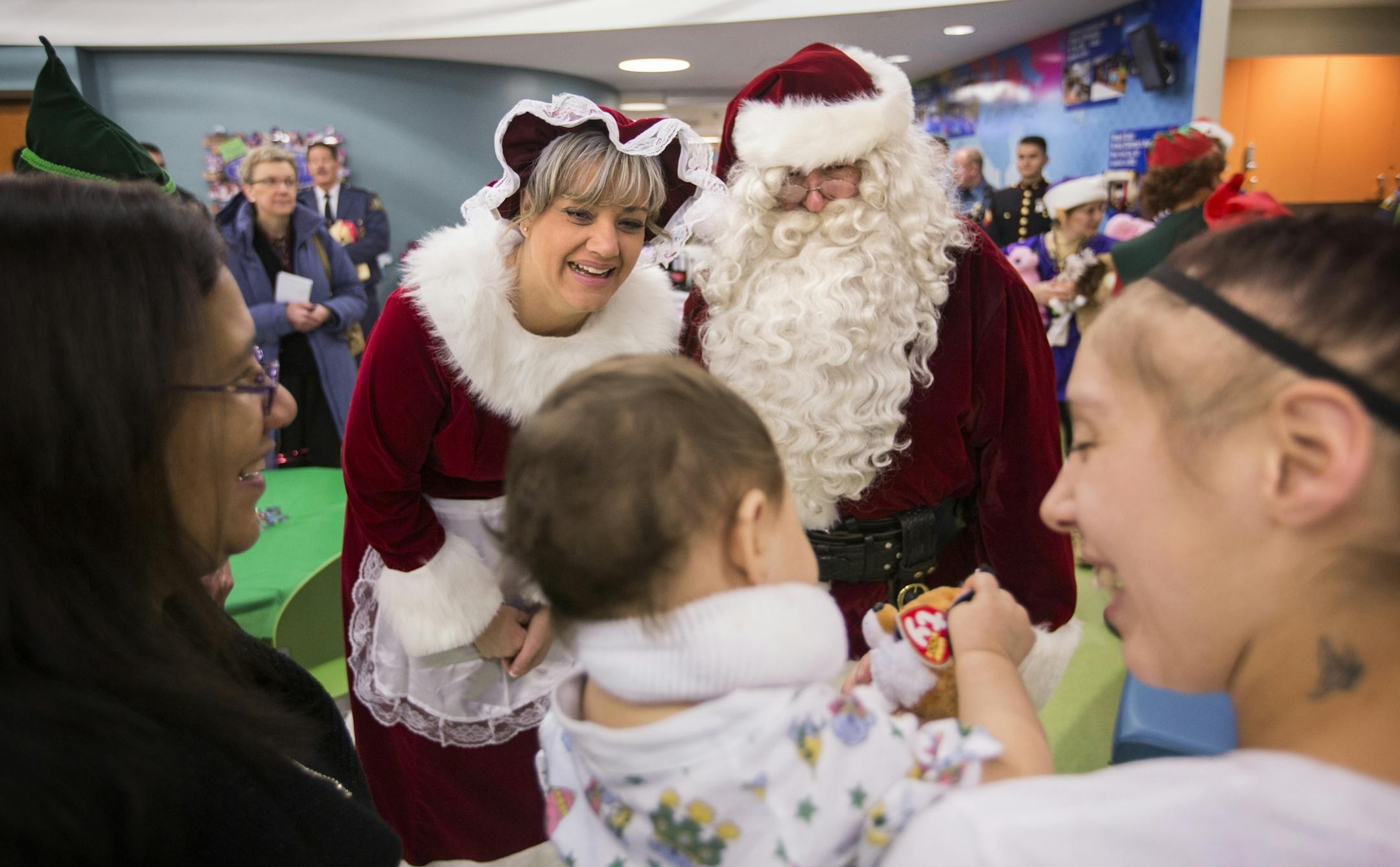 Santa Claus, played by retired St. Paul police officer Tim Bradley, and Mrs. Claus, played by St. Paul police officer Amy Rahlf, visit with nine-month-old patient Miiyah Saldivar and her mother Christina Hom, right, and grandmother Sandra Garcia, left, during a visit to Children's Hospitals in St. Paul on Thursday, December 17, 2015.