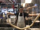 Demonstrating the art of hand-pulled noodles.