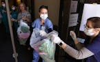 Abbott Northwestern Hospital workers formed a line as they helped unload 1,500 flowering spring plants donated by Bachman's Floral, Home & Garden in a