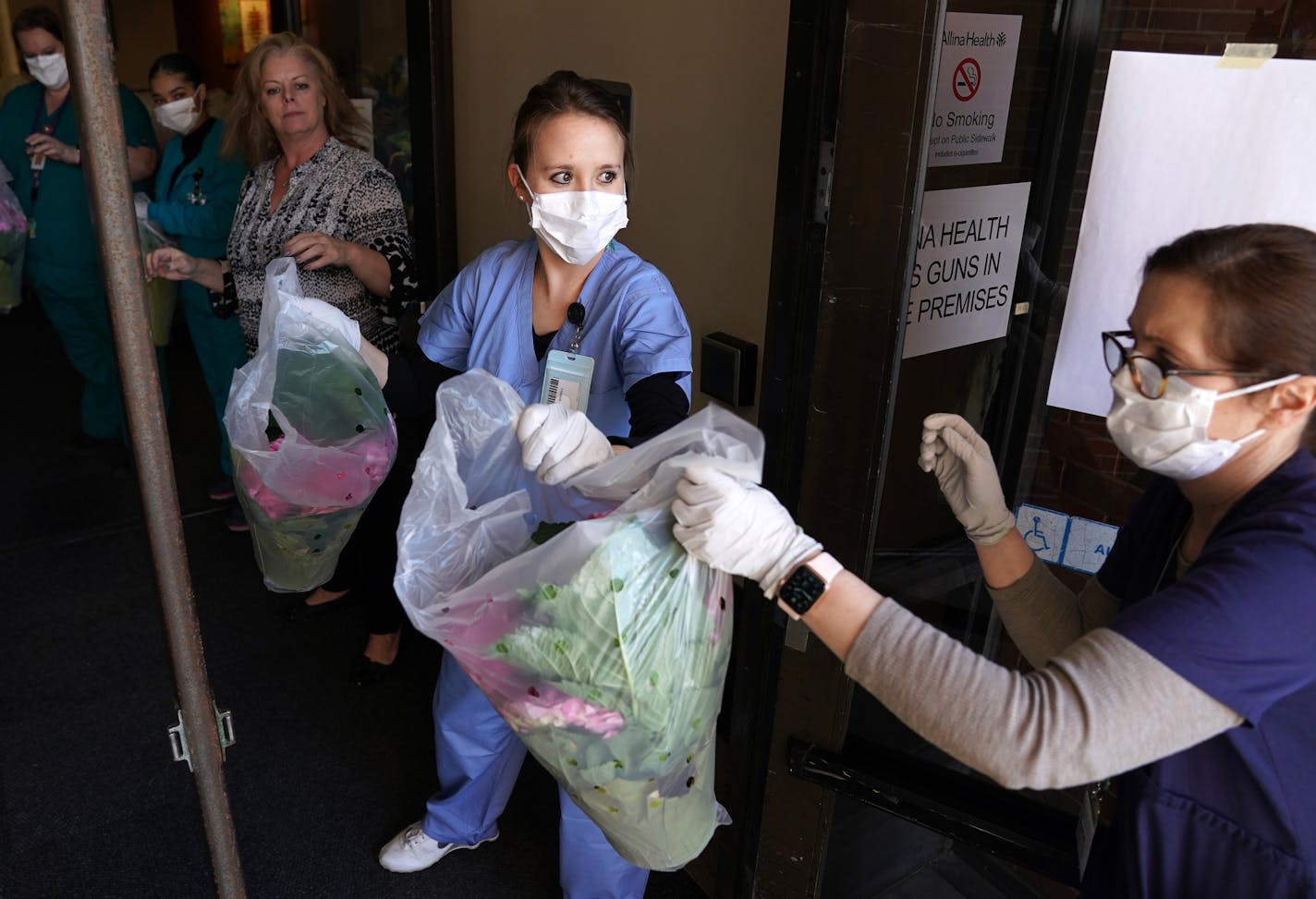 Abbott Northwestern Hospital workers formed a line as they helped unload 1,500 flowering spring plants donated by Bachman's Floral, Home & Garden in appreciation of the efforts.