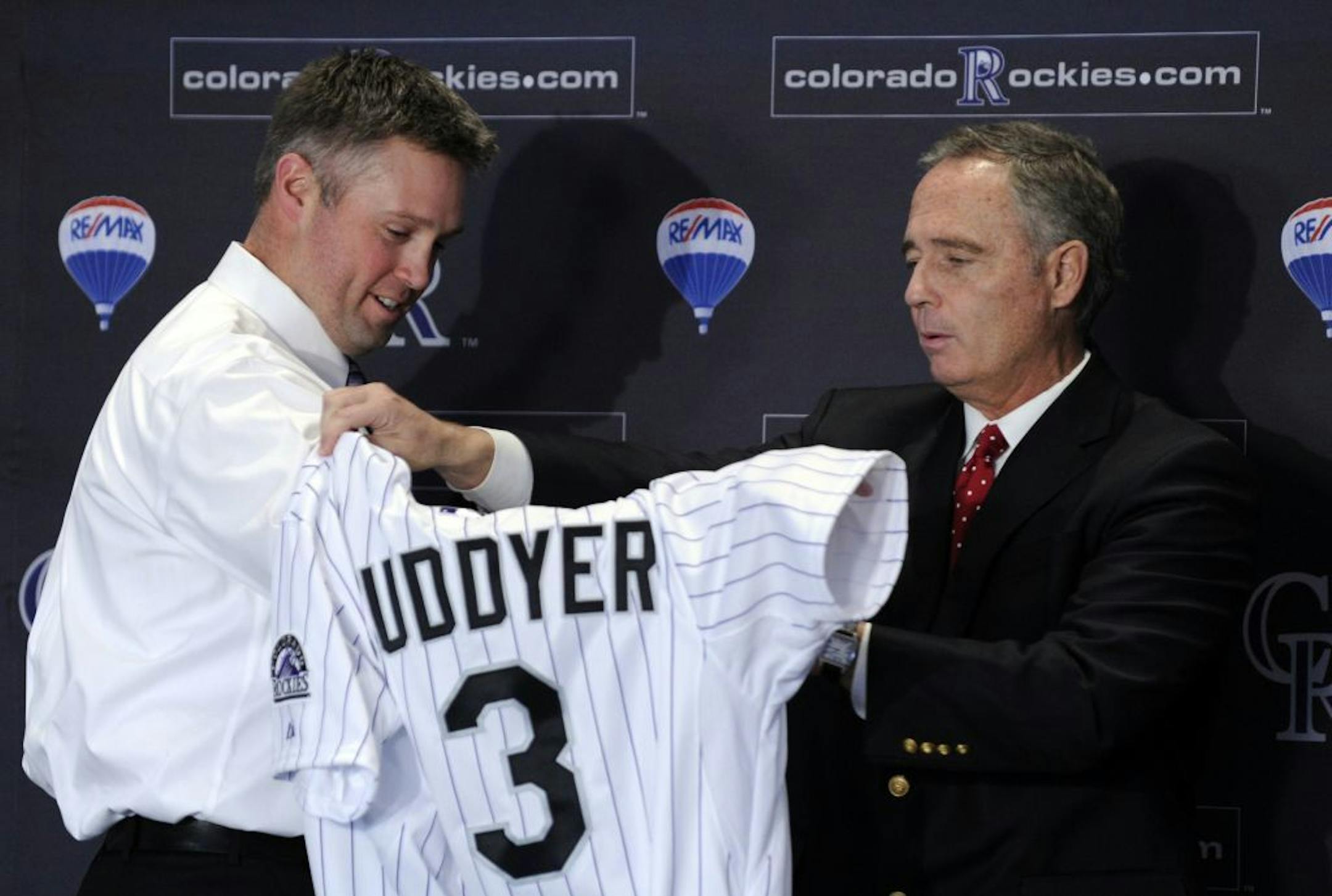 Michael Cuddyer tries on his Colorado Rockies jersey with the help of team general manager Dan O'Dowd during a news conference at Coors Field in Denver, Colo., Tuesday, Dec. 20, 2011. The 32-year-old outfielder spent 11 seasons in Minnesota before agreeing to a free-agent deal with the Rockies late last week. (AP Photo/The Denver Post, Hyoung Chang) MAGS OUT TV OUT MANDATORY CREDIT