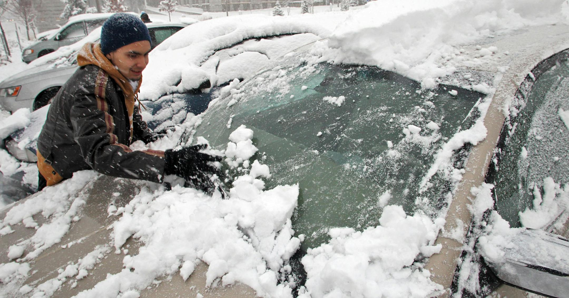 More than a foot of snow fell in the Twin Cities Sunday producing instant weather-copeing conditions. Andy Perez forgot his snow brush at home and had to clean the snow off his car by hand after getting off work at Regions Hospital.