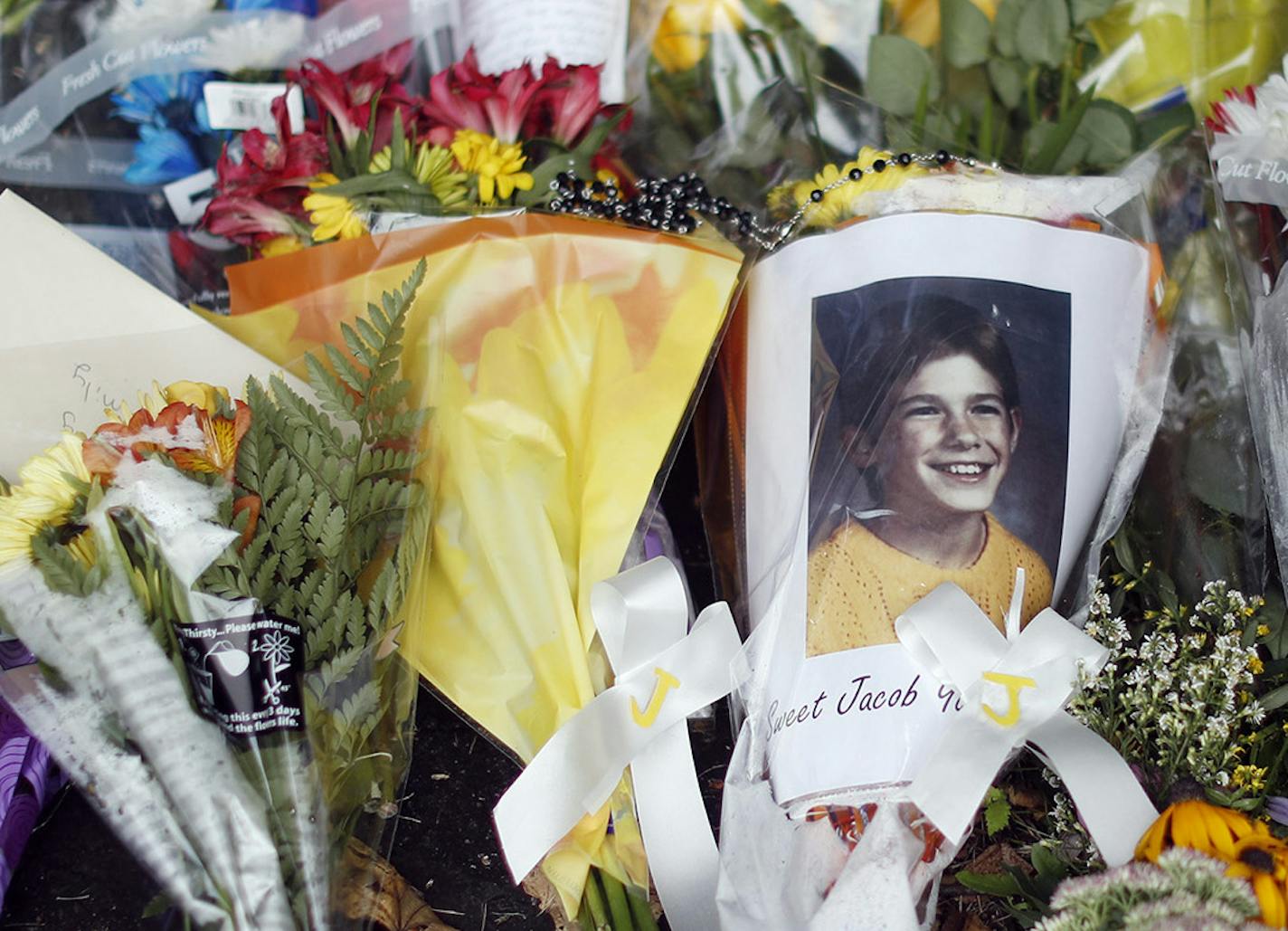 A photograph of Jacob Wetterling and flowers were placed at his parents' home Sunday in St. Joseph, Minn.