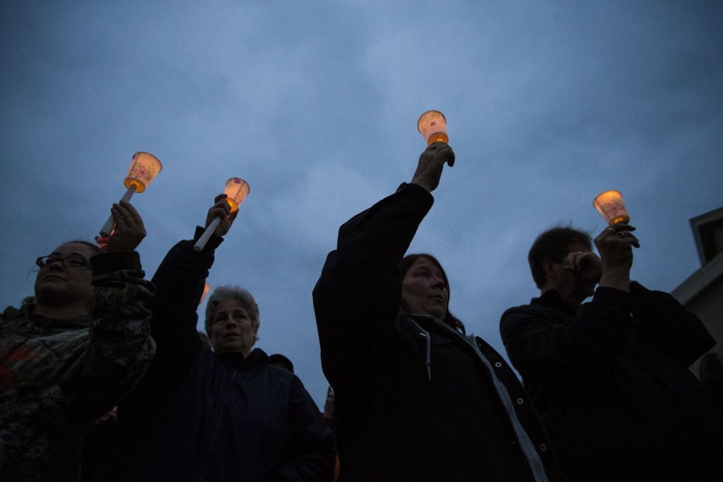 People raised their candles for Joseph Brunn in a moment of a candlelight vigil for him after his body was discovered earlier in day in the Mississippi River on Thursday October 8, 2015, outside the Holiday Inn in Otsego, Minn.,.