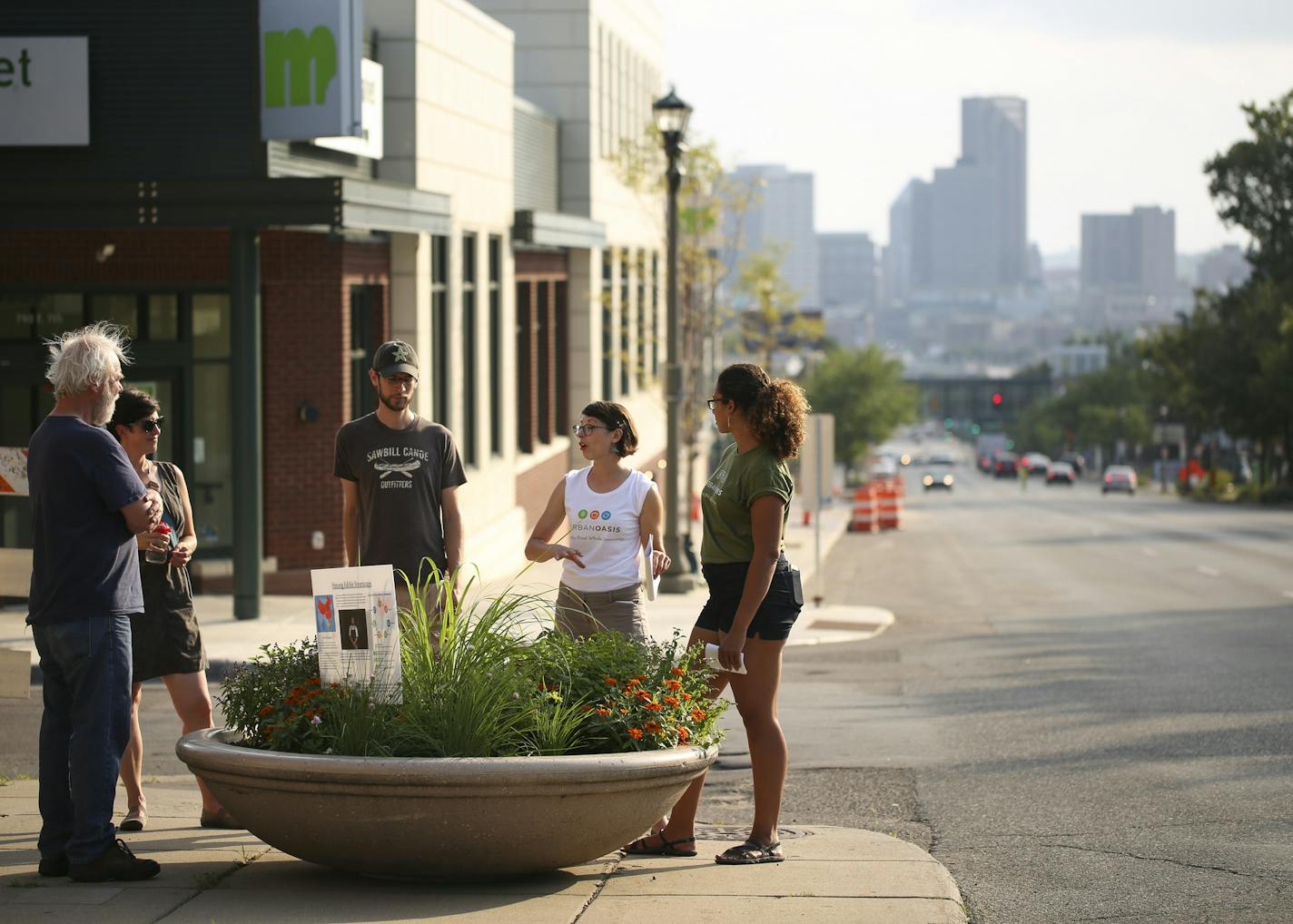 Kim Werst and Miah Ulysse, right, both of Urban Oasis led the tour of the container gardens on E. 7th St. Those on the tour included, from left, Paul Garding, Janelle Nivens, and Matt Frank, who listened as Werst spoke about plants that stem from the Hmong food tradition. ] JEFF WHEELER &#xef; jeff.wheeler@startribune.com Urban Oasis, a sustainable food center, hosted a walking tour of its "Edible Streetscapes" project in St. Paul Wednesday evening, July 20, 2016. A series of ten planters along