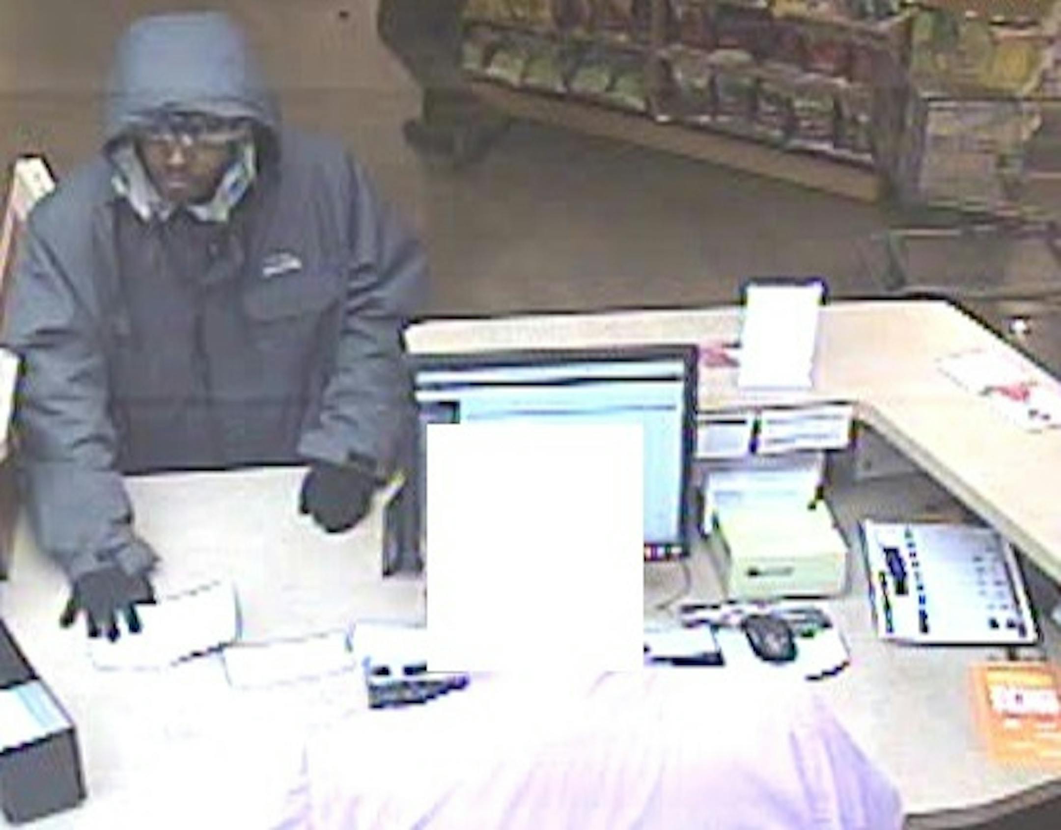 This bank surveillance photo was supplied with the teller's image removed.