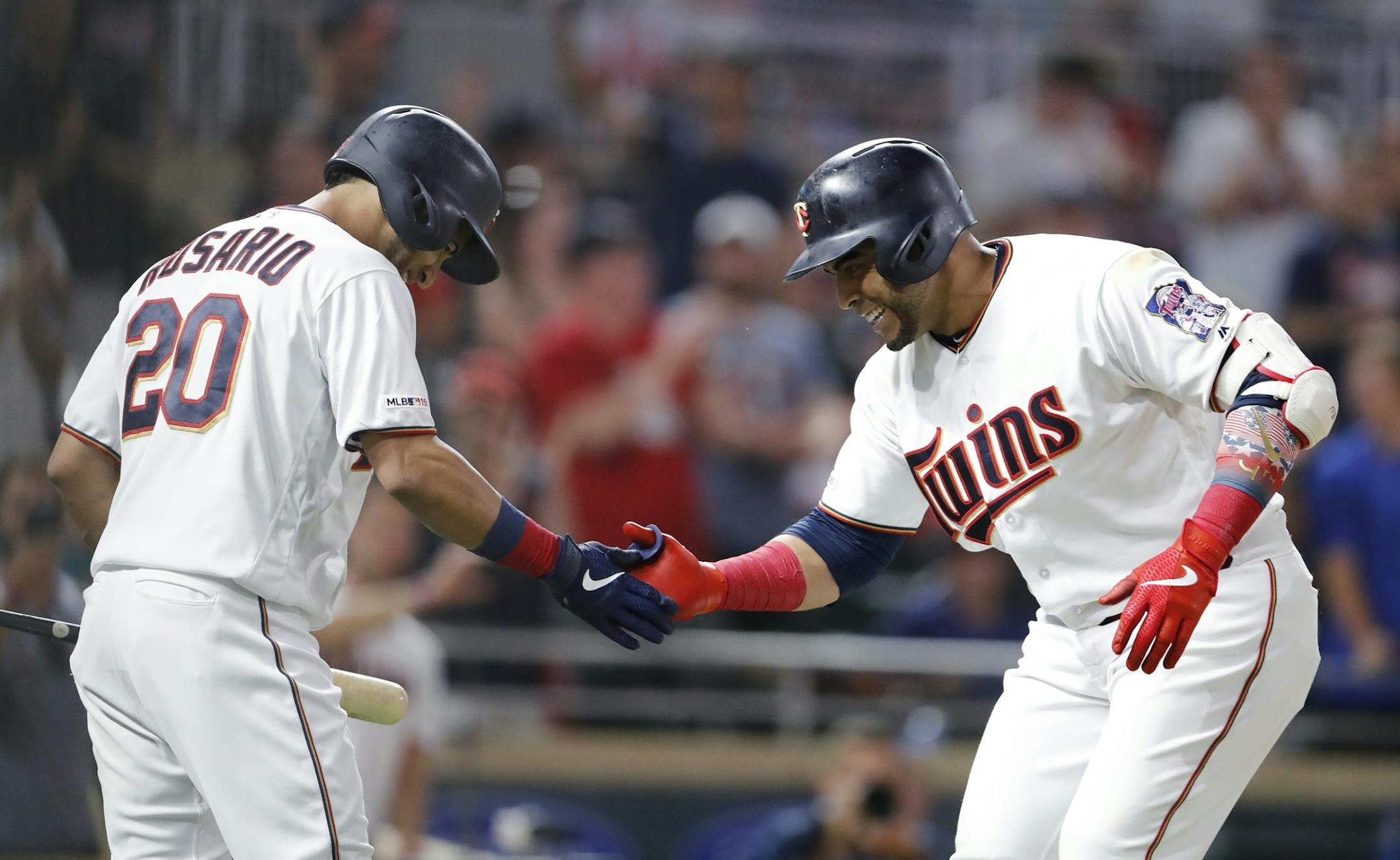 Minnesota Twins designated hitter Nelson Cruz (23) celebrates a home run in the seventh inning with Minnesota Twins left fielder Eddie Rosario (20), left.