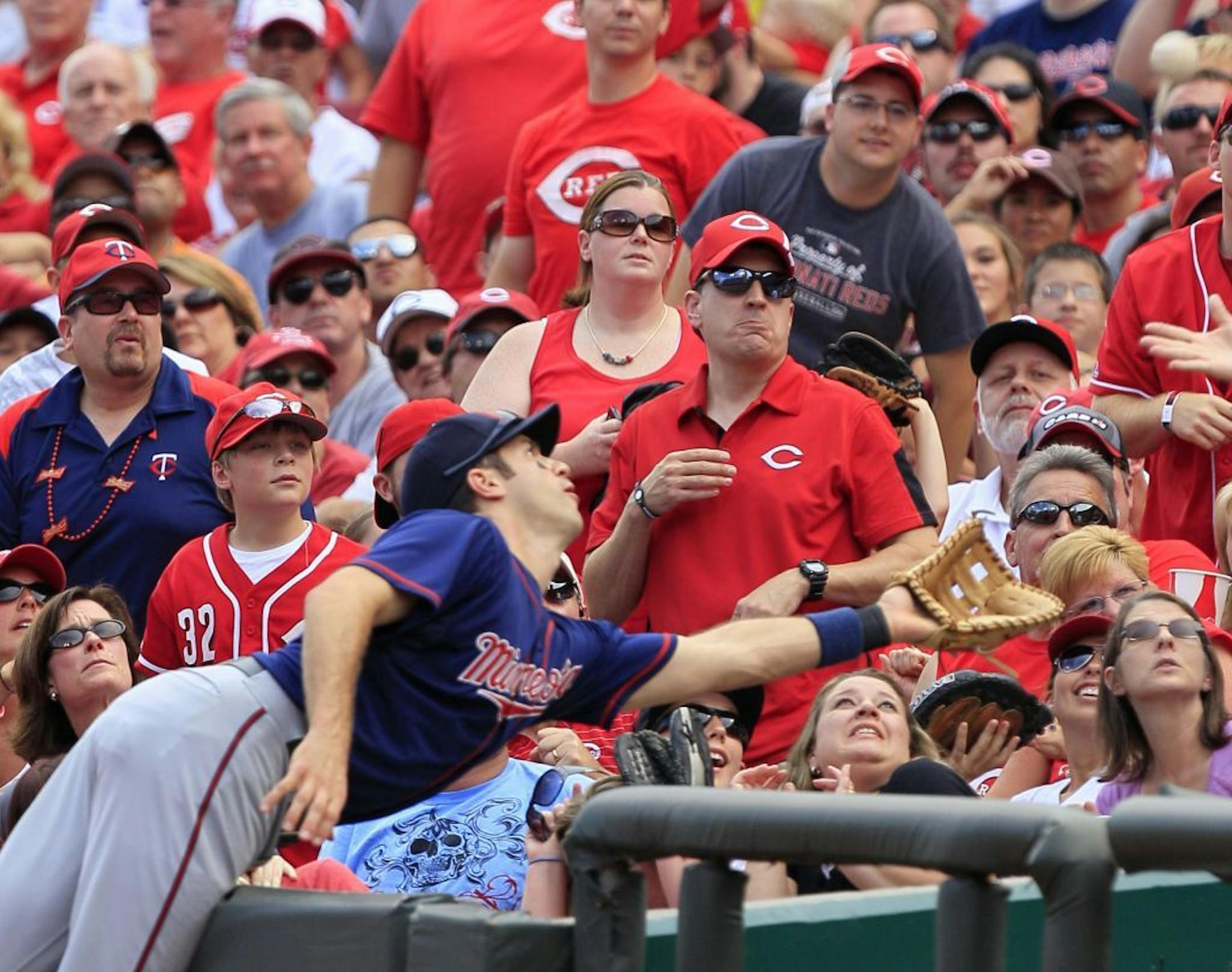 Minnesota Twins first baseman Joe Mauer cannot reach a foul ball hit by Cincinnati Reds' Zack Cozart in the first inning of a baseball game on Saturday, June 23, 2012, in Cincinnati.
