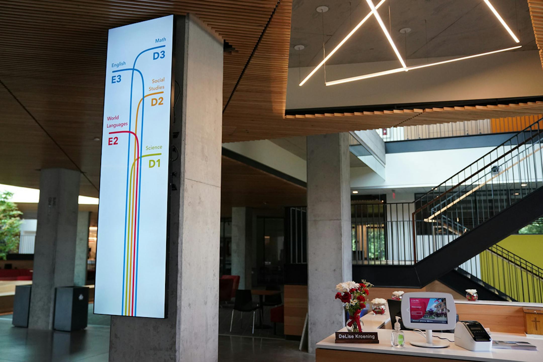 An illuminated sign near the main entryway guides students through the new building.