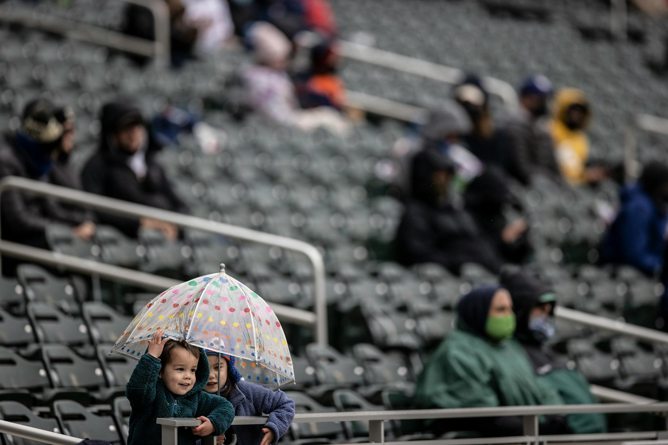 Twins fans covered up as light snow and rain fell.