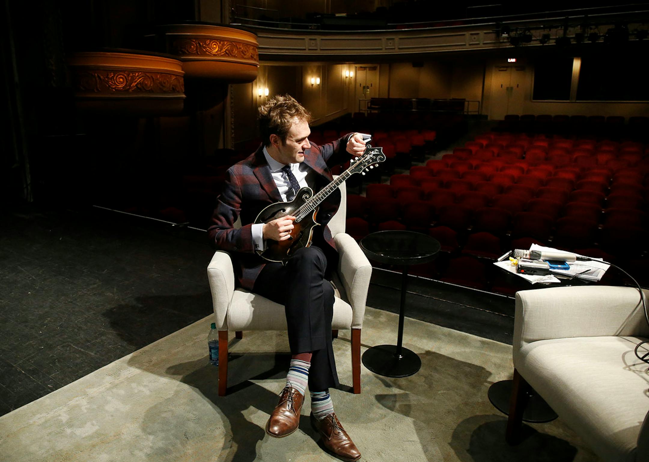 Chris Thile tunes his mandolin on the stage of the Fitzgerald Theater in St. Paul, Minn., Tuesday, April 5, 2016.