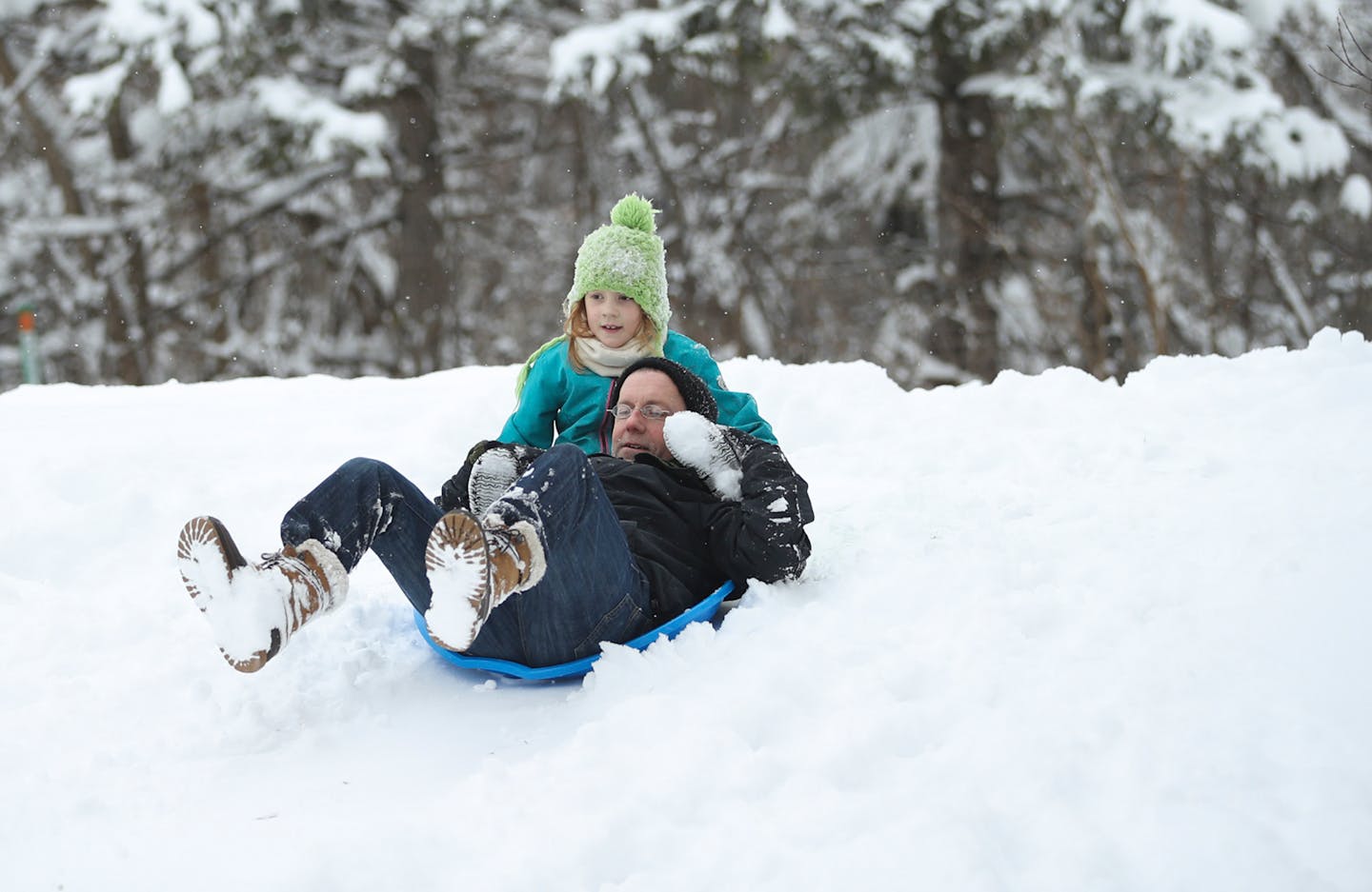 Lyla Fitzgerald, 7, and her dad, Tom, broke in the saucers they bought today on a hill alongside Minnehaha Creek at 12th Avenue S. in Minneapolis Sunday afternoon.