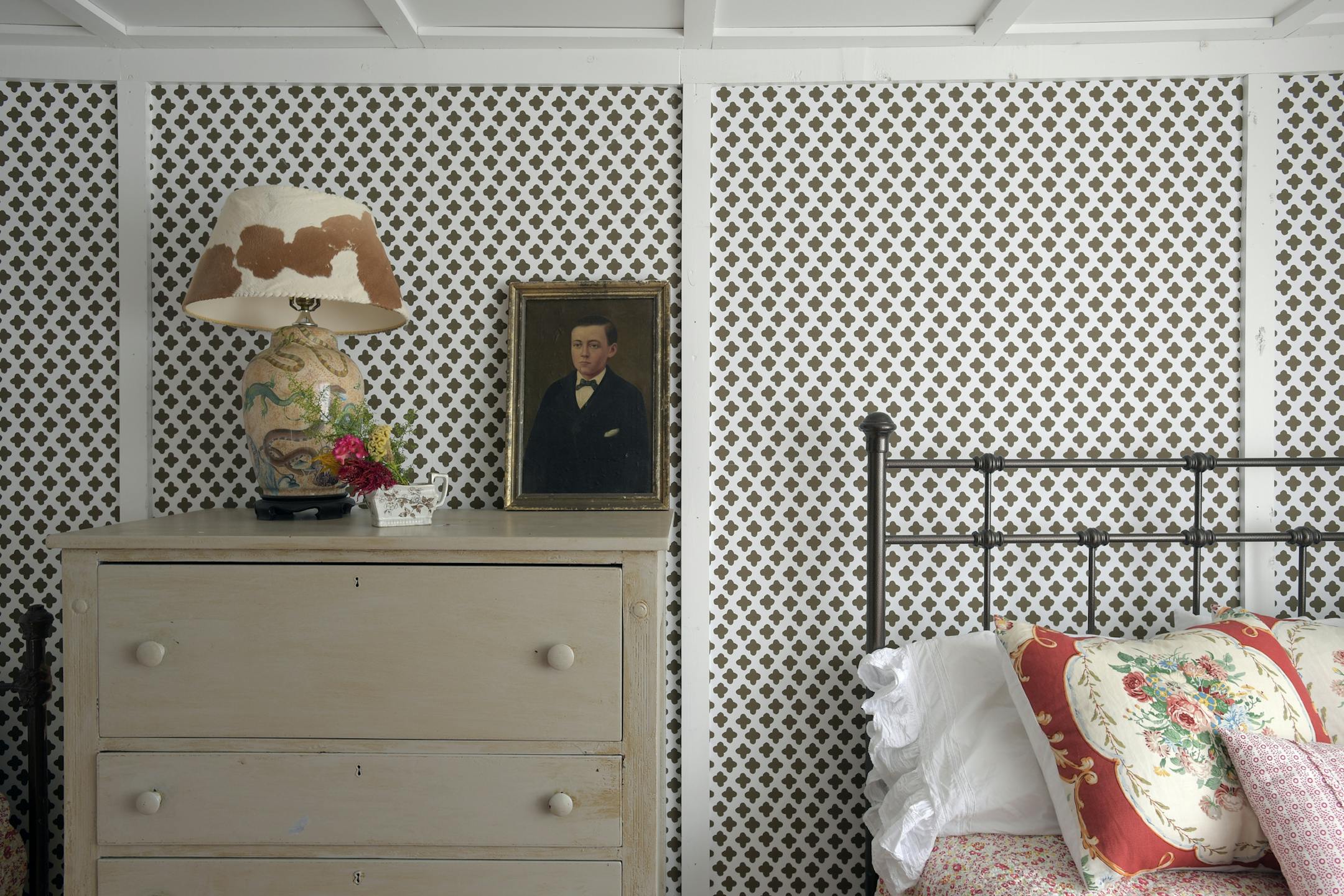 A corner of the guest bedroom shows a pillow Gibson made out of an old window treatment and a lampshade she had sewn from a cowhide she found at a flea market. The brown and white quatrefoil wallcovering is her own design. MUST CREDIT: Washington Post photo by John McDonnell.