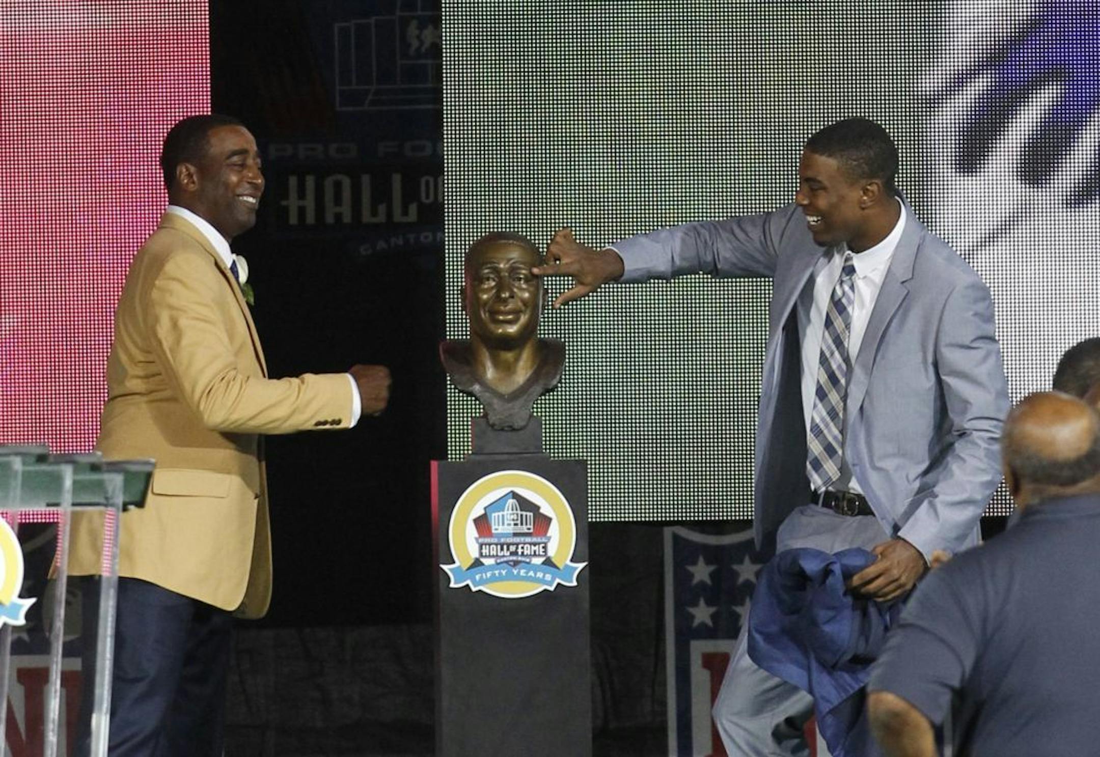 Duron Carter touches the bust of his father, Cris Carter, left, after presenting his dad during the Pro Football Hall of Fame Enshrinement Ceremony on Saturday, August 3, 2013, in Canton, Ohio.