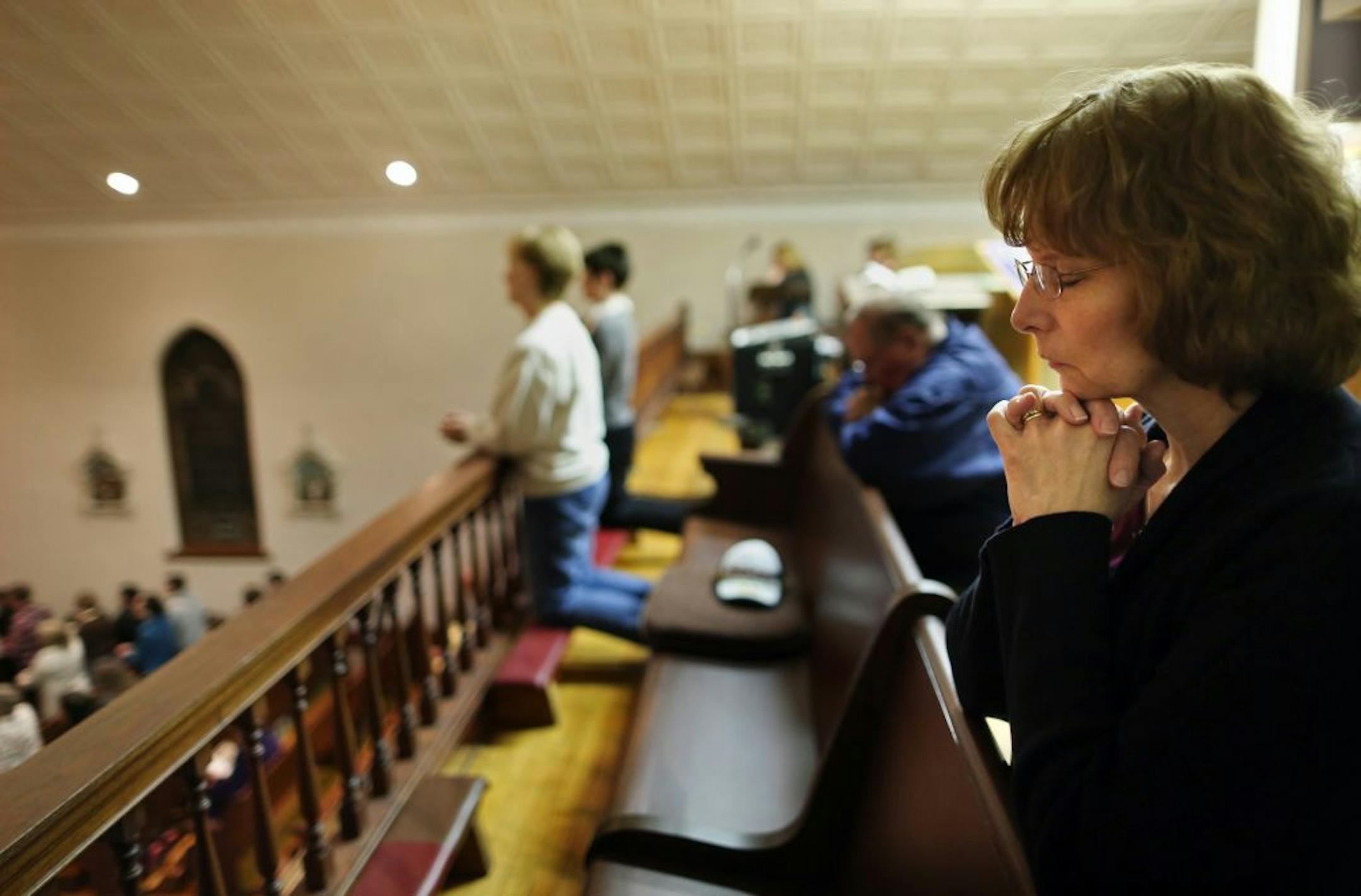 Diane Weckman prayed from the balcony (where she sings in the choir) during a Holy Thursday service at St. Scholastica Church near New Prague, Minn. on Thursday, April 5, 2012. Weckman was a member of St. Benedict's church near her house in New Prague. The church closed Jan. 2011. It along with three other church parishes in the area had to merge as part of the archdiocese reorganization plan announced fall 2010.