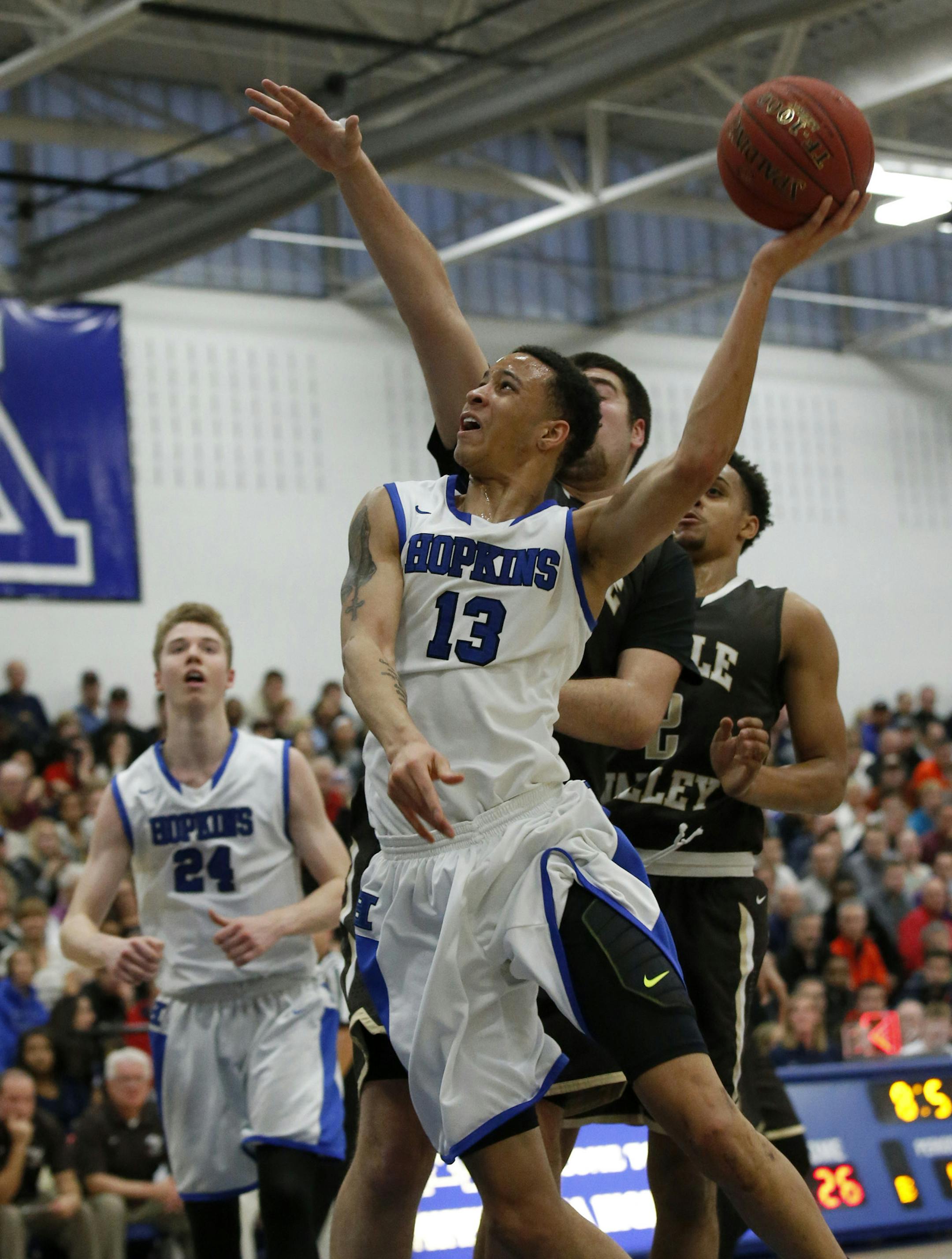 Hopkins guard Amir Coffey (13) goes to the basket against Apple Valley center Brock Bertram during the first half in Minnetonka, Saturday, Dec. 12, 2015. ( Photo/Ann Heisenfelt) ORG XMIT: 596959 PREP121315 03