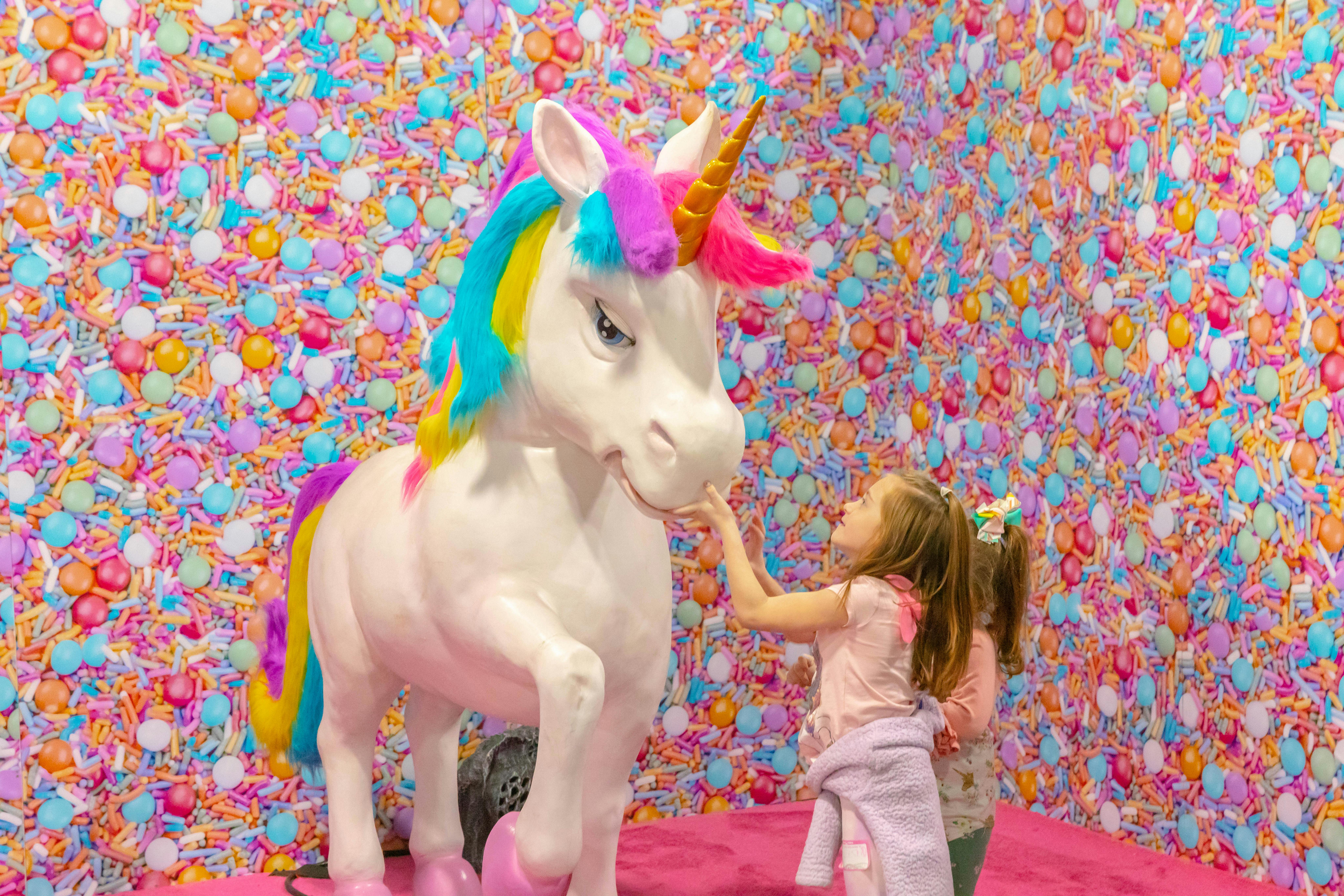 The life-size unicorns each have a distinct color scheme and personality, evoking My Little Pony toys parents may remember.