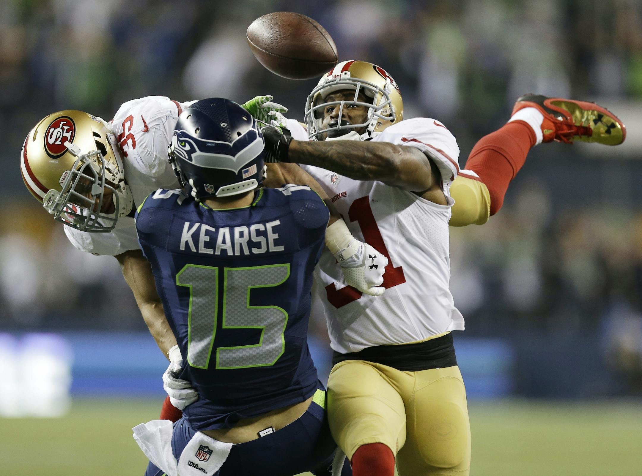 San Francisco 49ers' Eric Reid (35) and Donte Whitner (31) break up a pass intended for Seattle Seahawks' Jermaine Kearse during the second half of the NFL football NFC Championship game Sunday, Jan. 19, 2014, in Seattle.