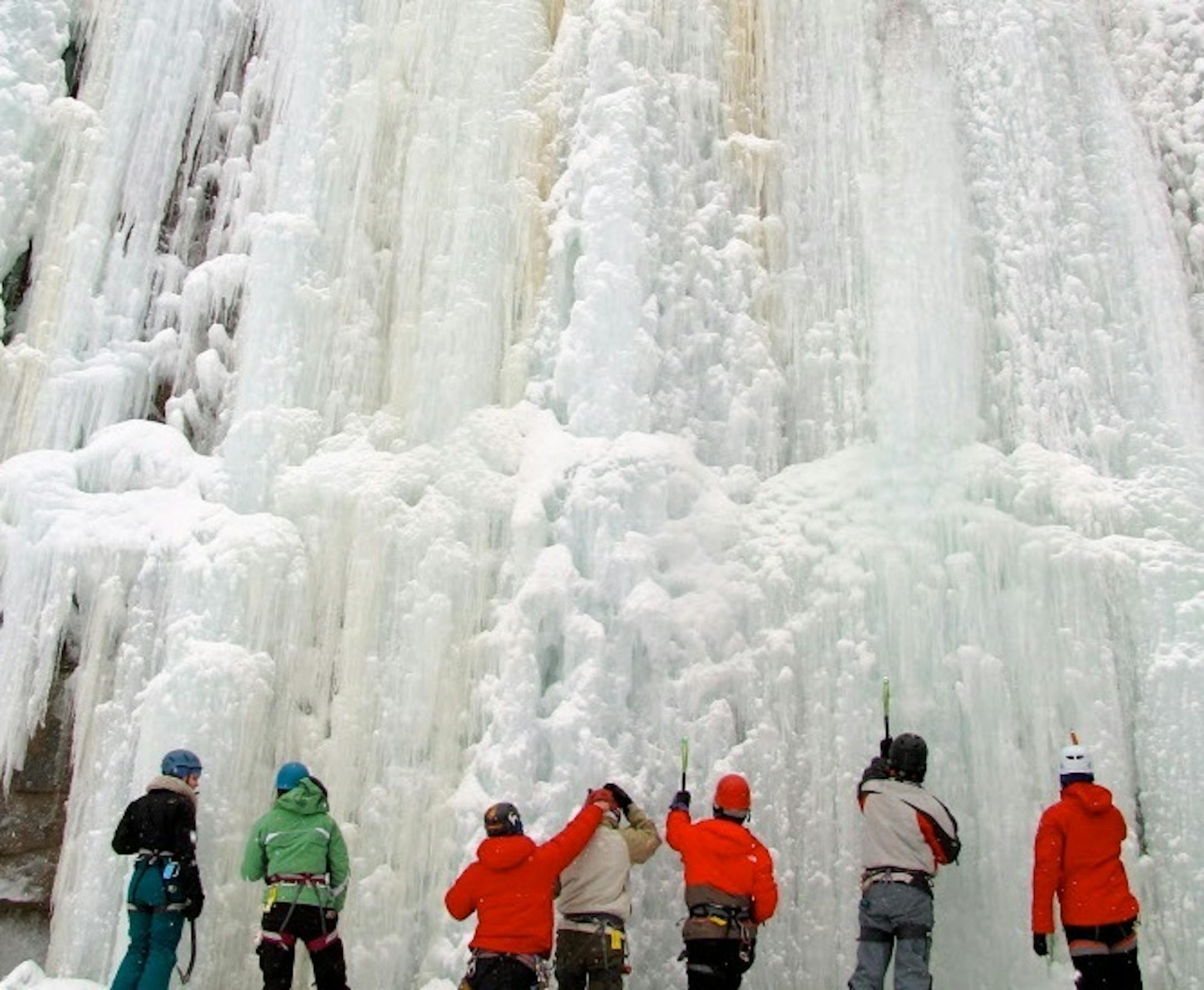 Photo by Lisa Meyers McClintick. Two instructors from Twin Cities-based Vertical Endeavors coaches a group of new ice climbers on how to get their ice axes securely picked into frozen wall at Sandstone�s Robinson�s Quarry.