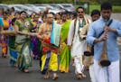 Chief priest Sri Ronur Murali led dozens of devotees in a procession that walked with spices, food and other offerings for the gods to be burned in a 
