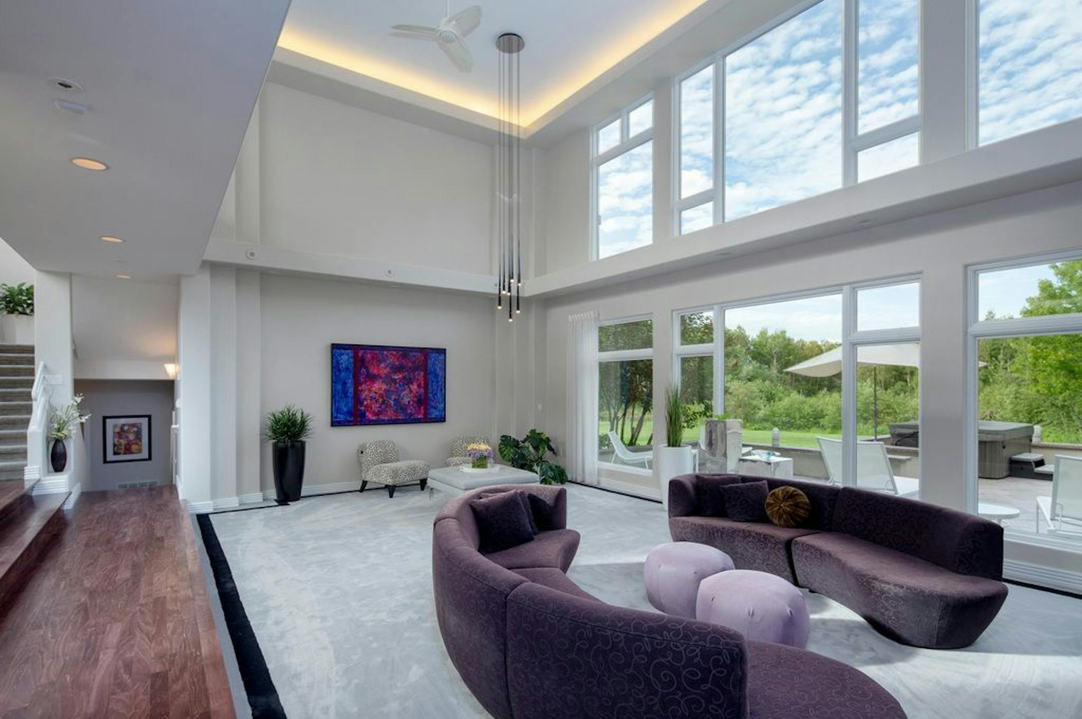 The living room has a wall of windows overlooking the large backyard. The home sits on 1.6 acres with its own pond.