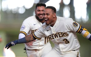 Milwaukee's Orlando Arcia celebrates with teammates after driving in the winning run during the 10th inning of the team's Opening Day game against the