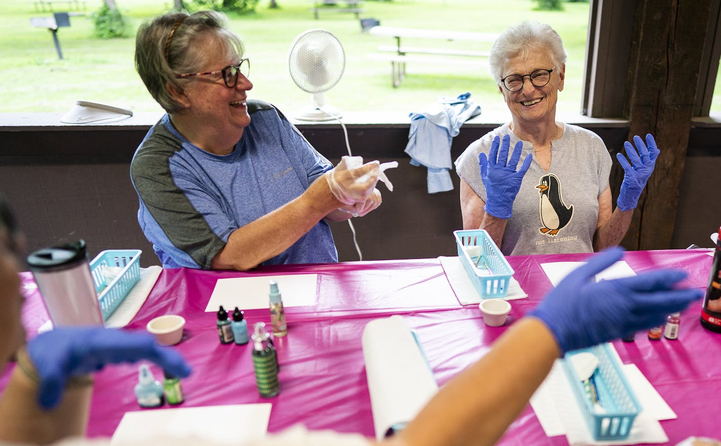 Mary McDougall, left, and Jan Parkins participate in a painting class during the camping trip.