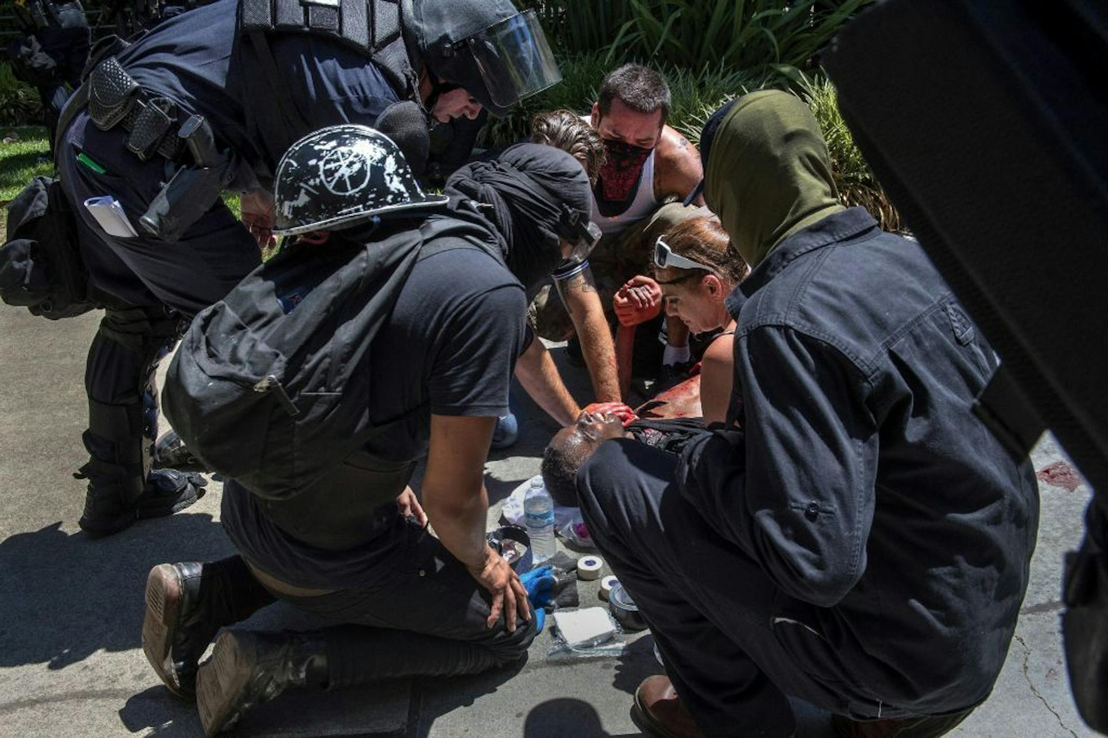 A victim is attended after he was stabbed during a rally at the State Capitol in Sacramento, Calif., on Sunday, June 26, 2016. Sacramento Fire Department spokesman Chris Harvey says a rally by KKK and other right-wing extremists groups turned violent Sunday when they were met by counterprotesters.